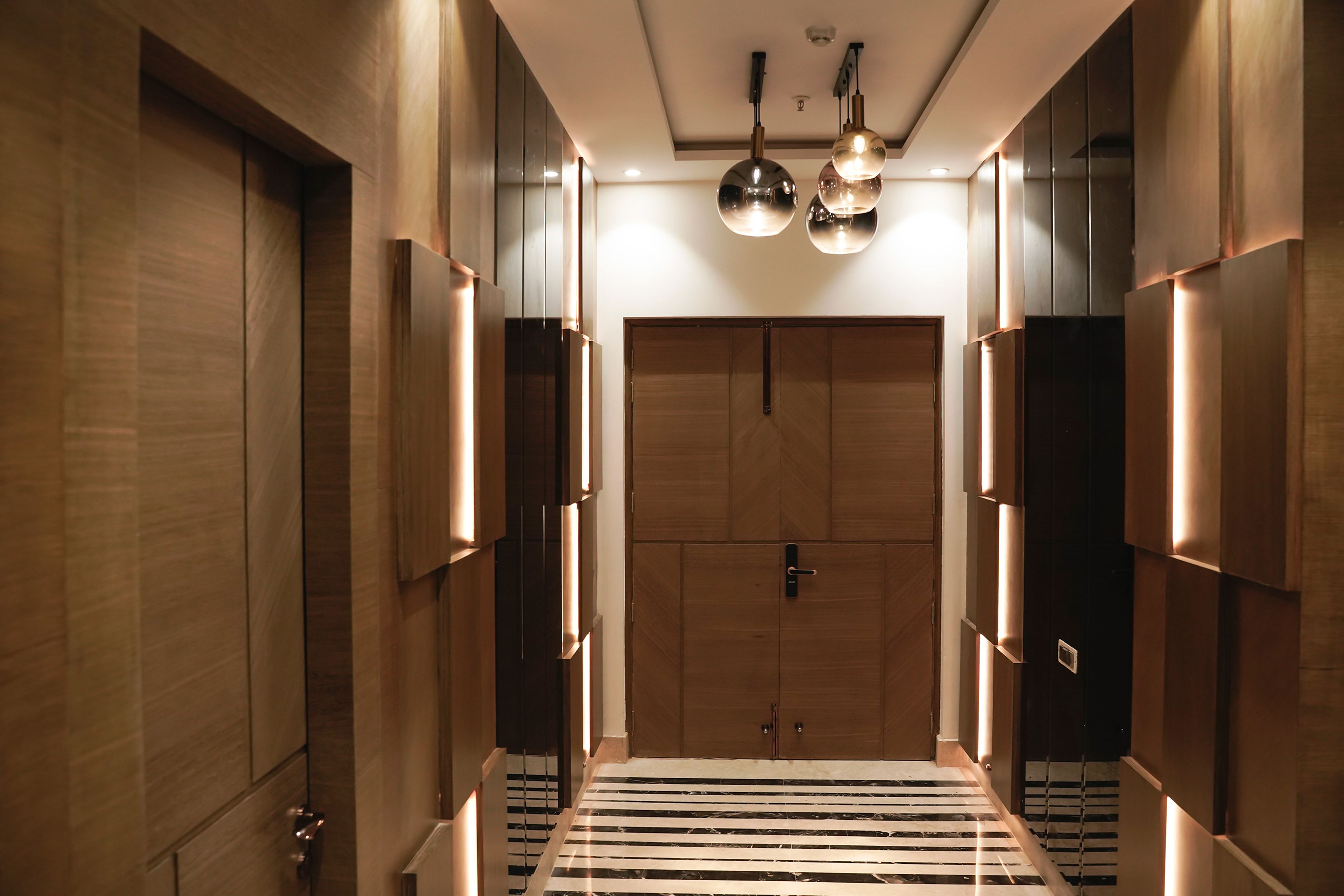 Foyer Design with Wooden Door and Chandelier Lighting