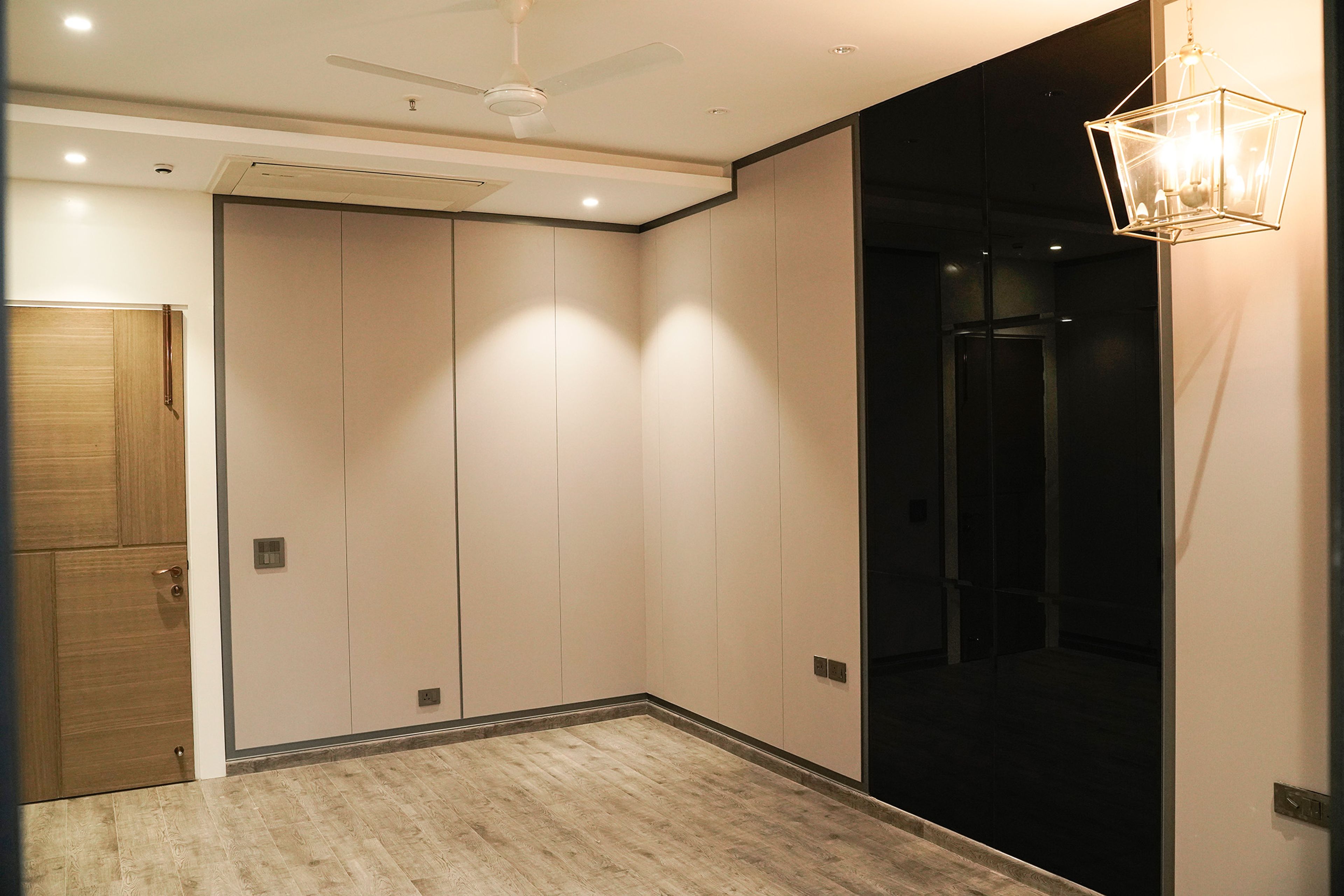 Beige Wall Design with Black Sliding Wardrobe