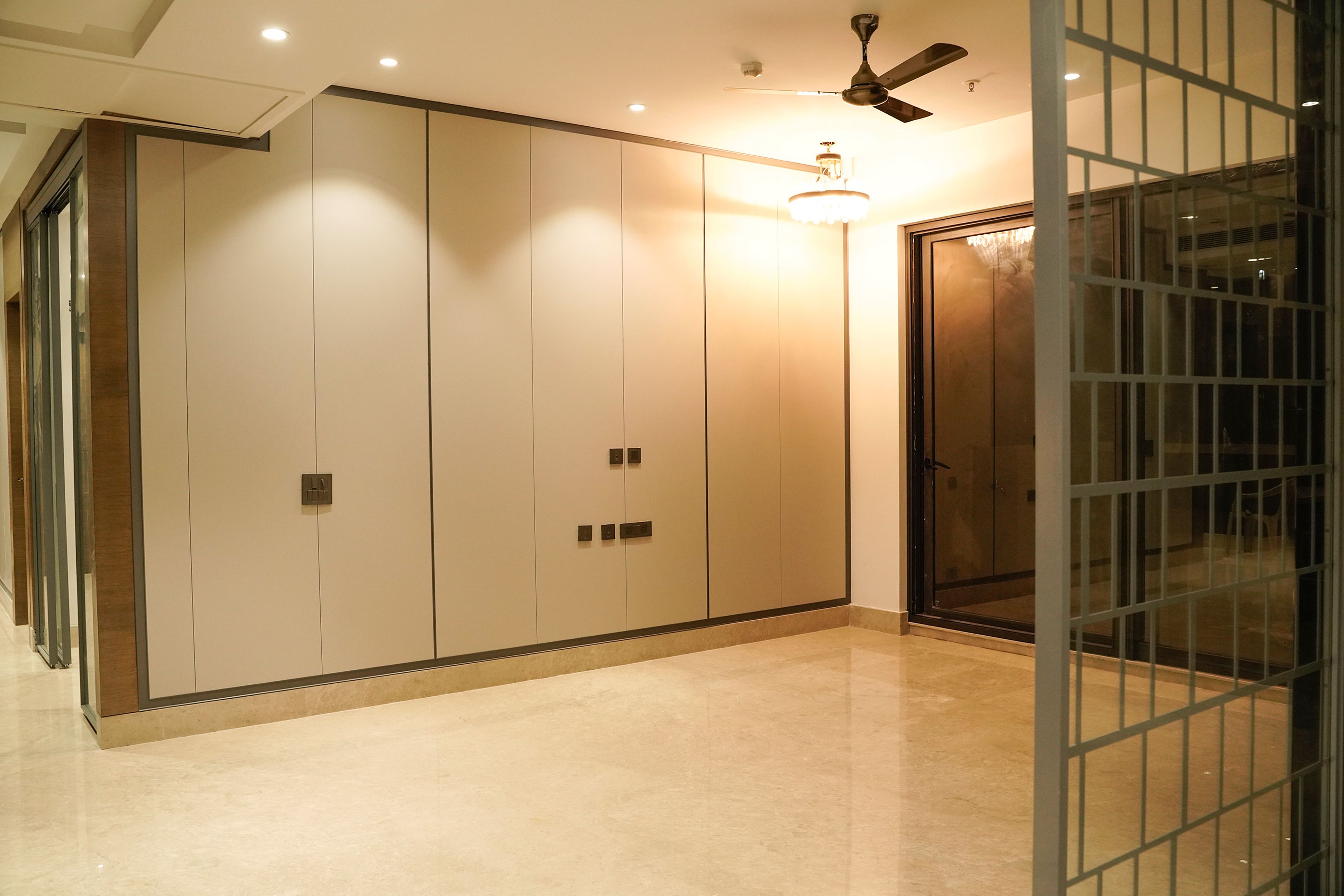 Beige Wall Design with Black Trims and Chandelier Lighting