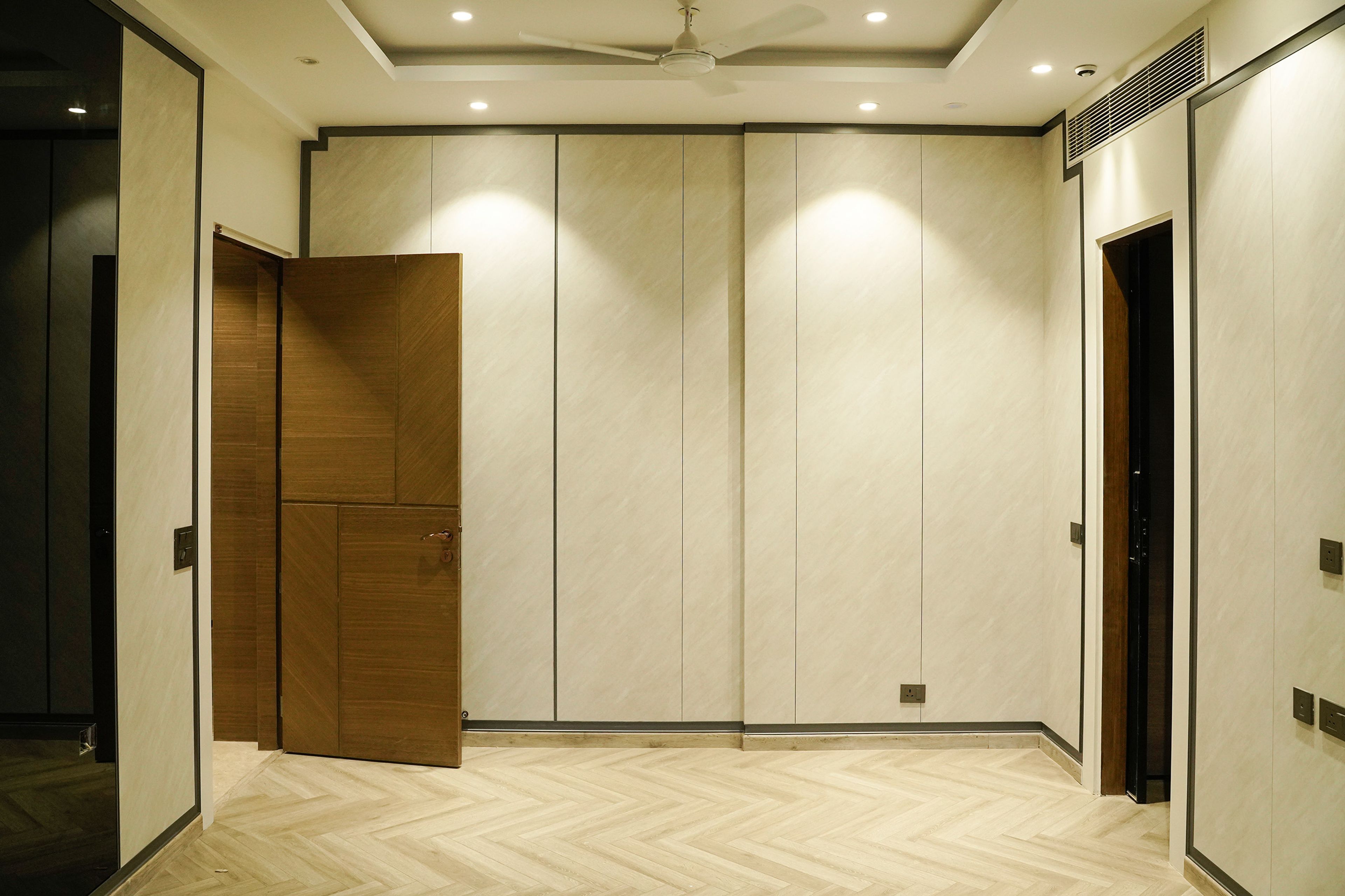 Wall Design with Patterned Wallapaper with Black Vertical Inlays and Wooden Flooring