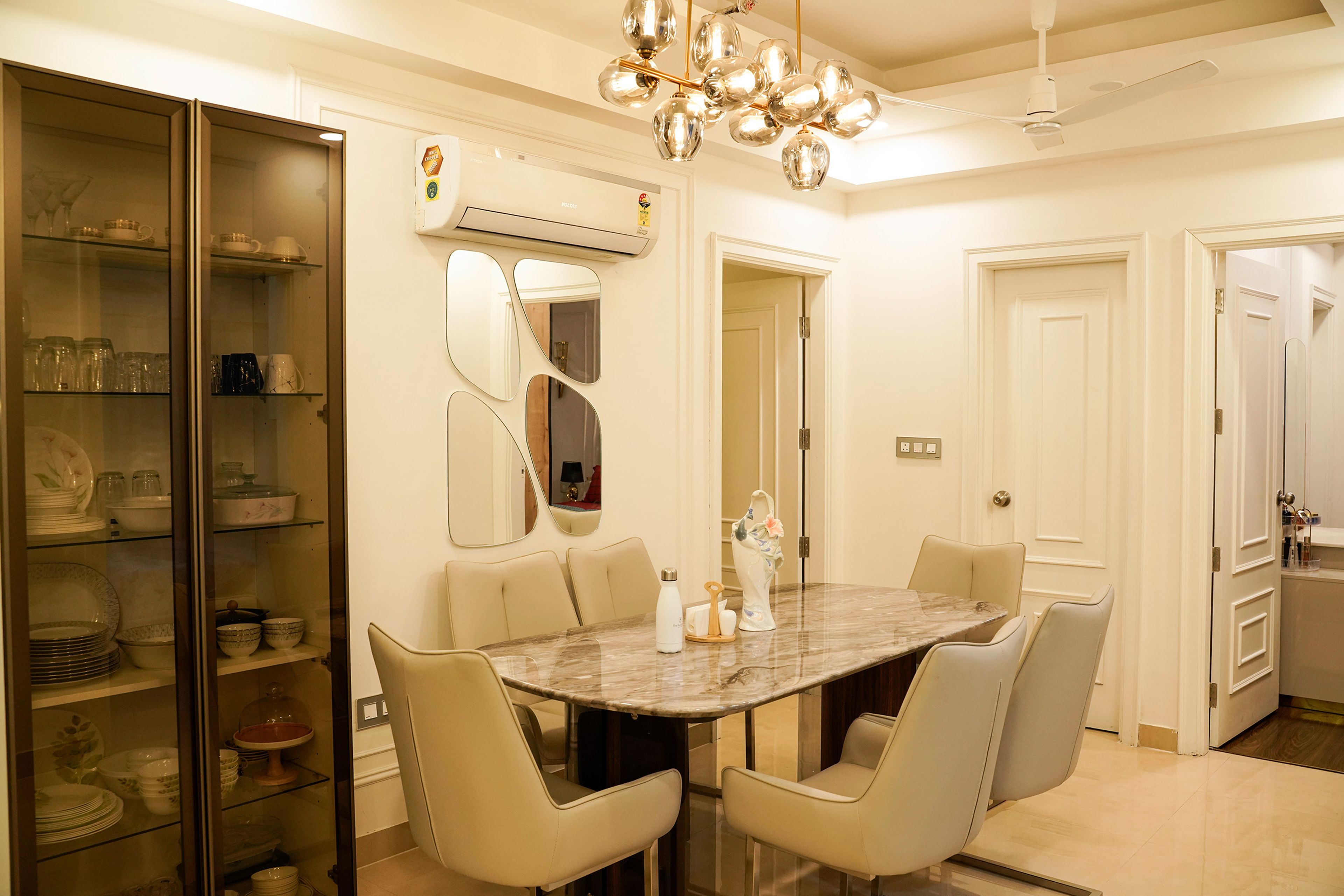 Dining Room Design with 6-Cream Chairs, Marble Table and Tinted Glass Crockery Unit