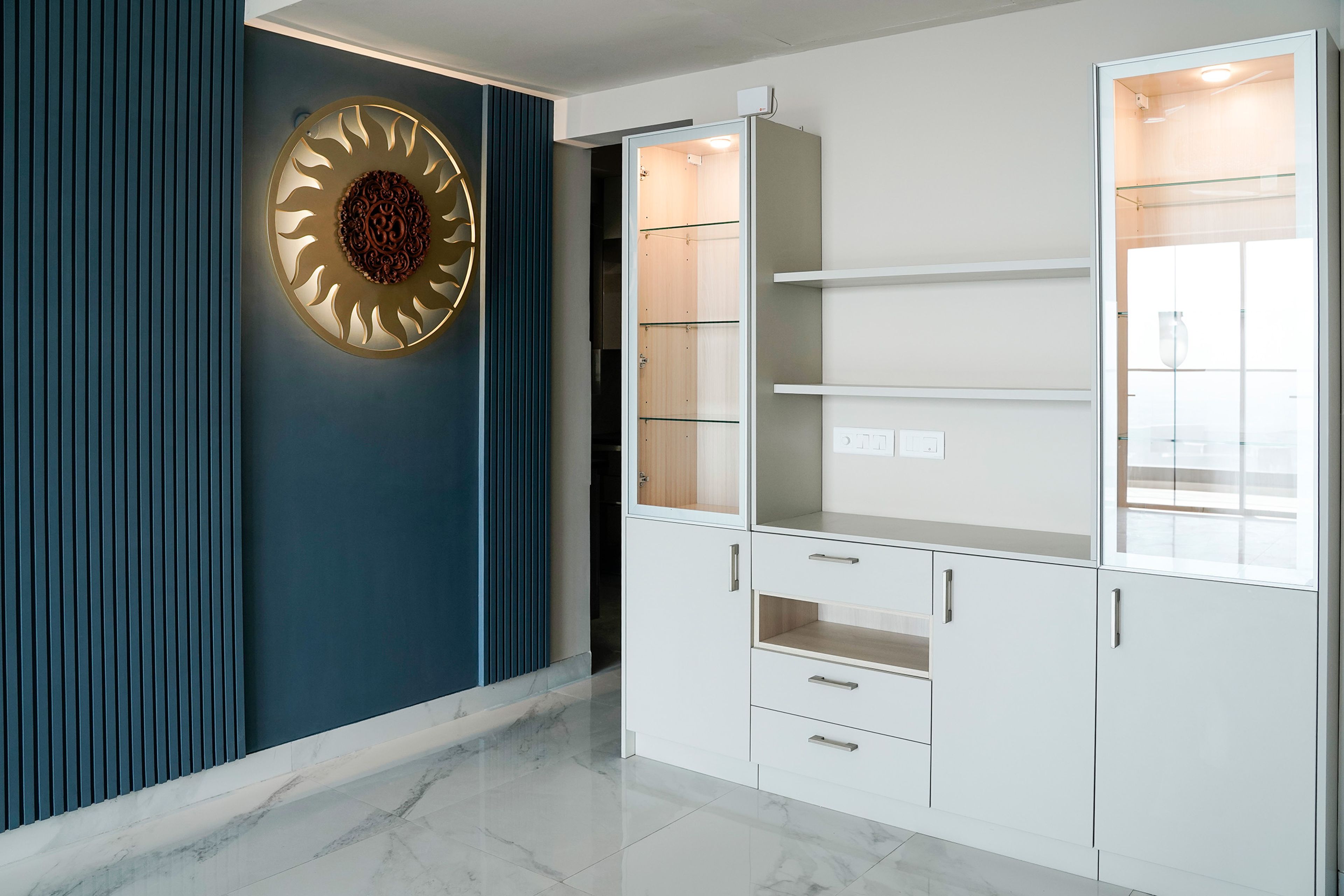White Crockery Unit Design with Under Cabinet Lighting and Blue Wall with Panels