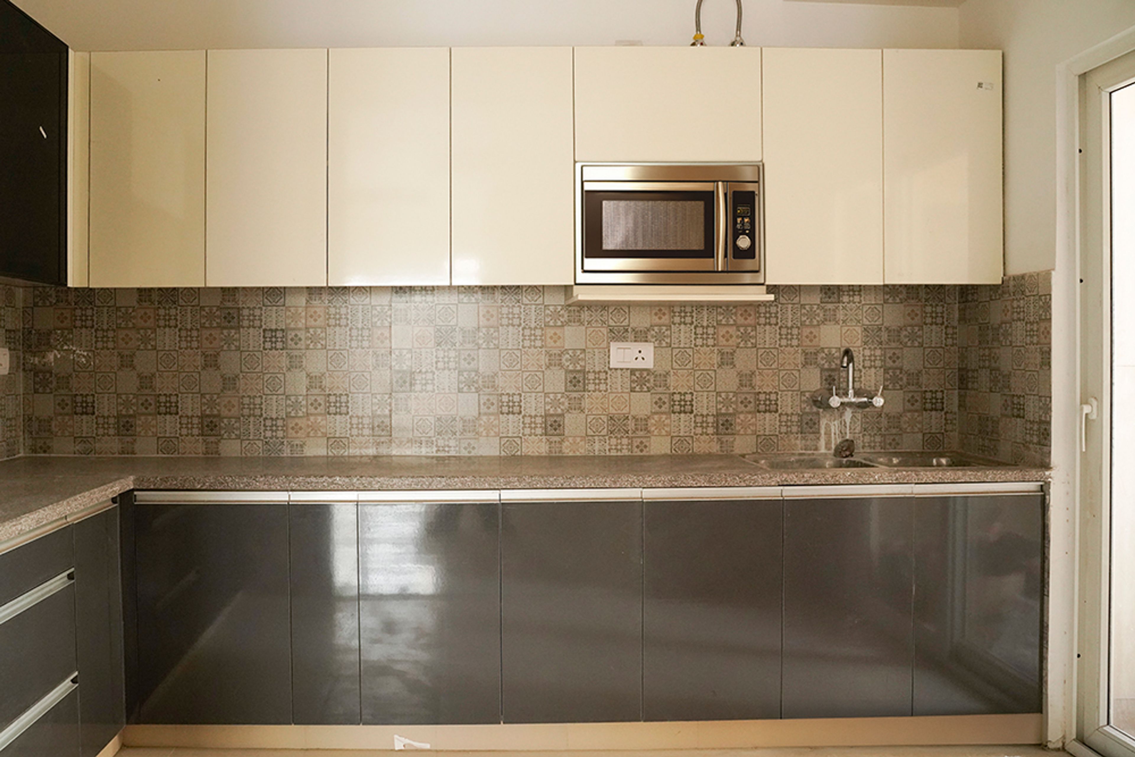 L-Shaped Kitchen Design with Moroccan Tiles Backsplash and Cream Wall Cabinets