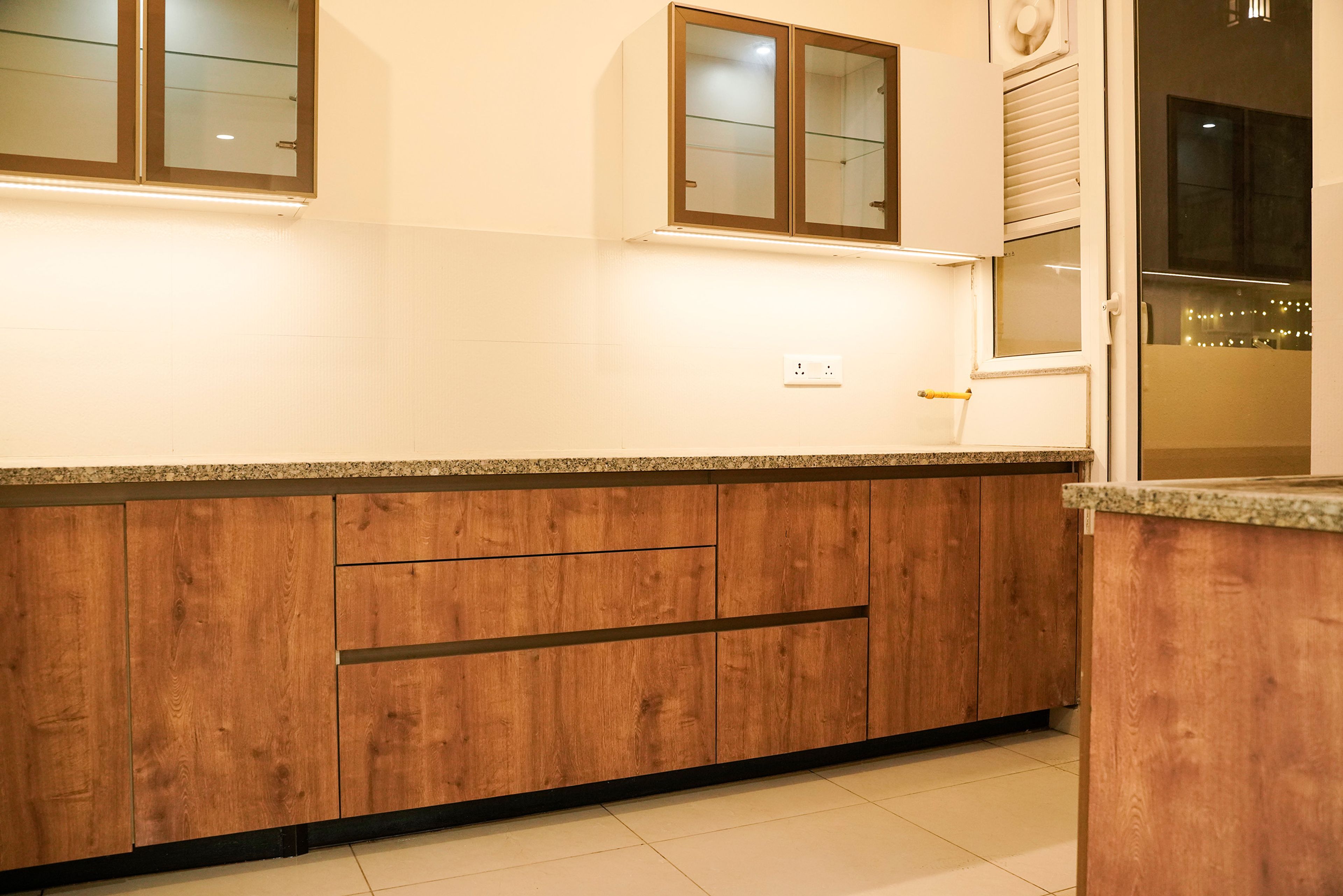 L-Shaped Kitchen Design with Wooden Base Cabinets and Granite Countertop