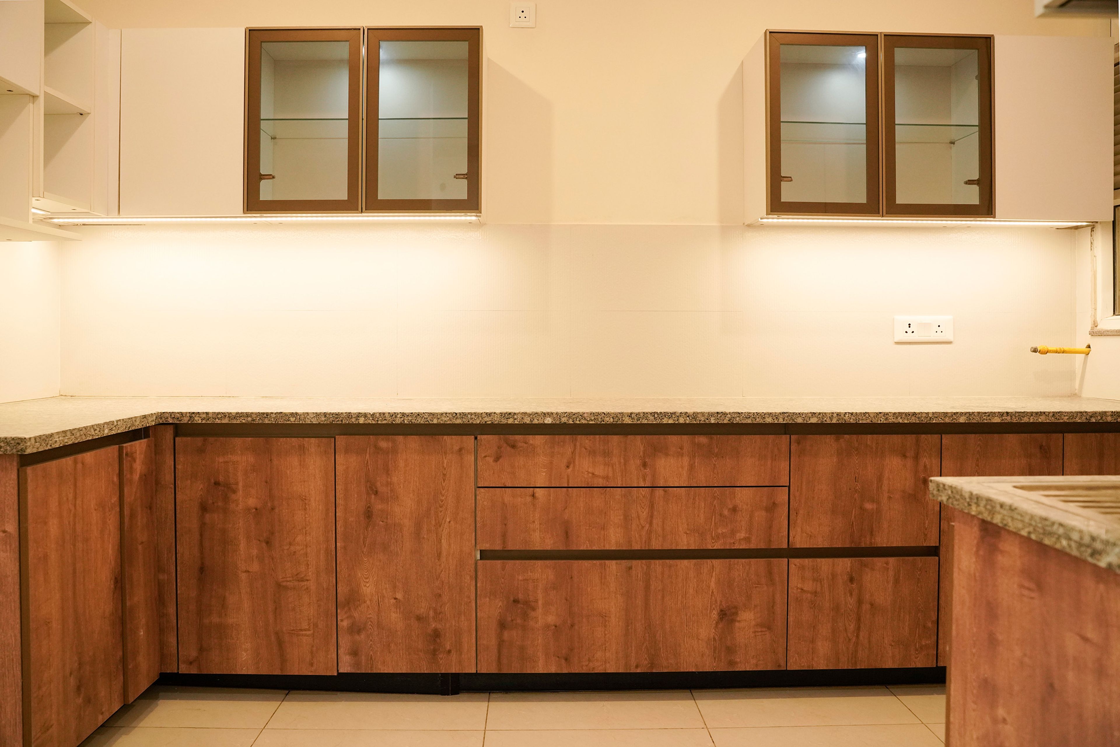 L-Shaped Kitchen Design with Wooden Base Cabinets and Granite Countertop