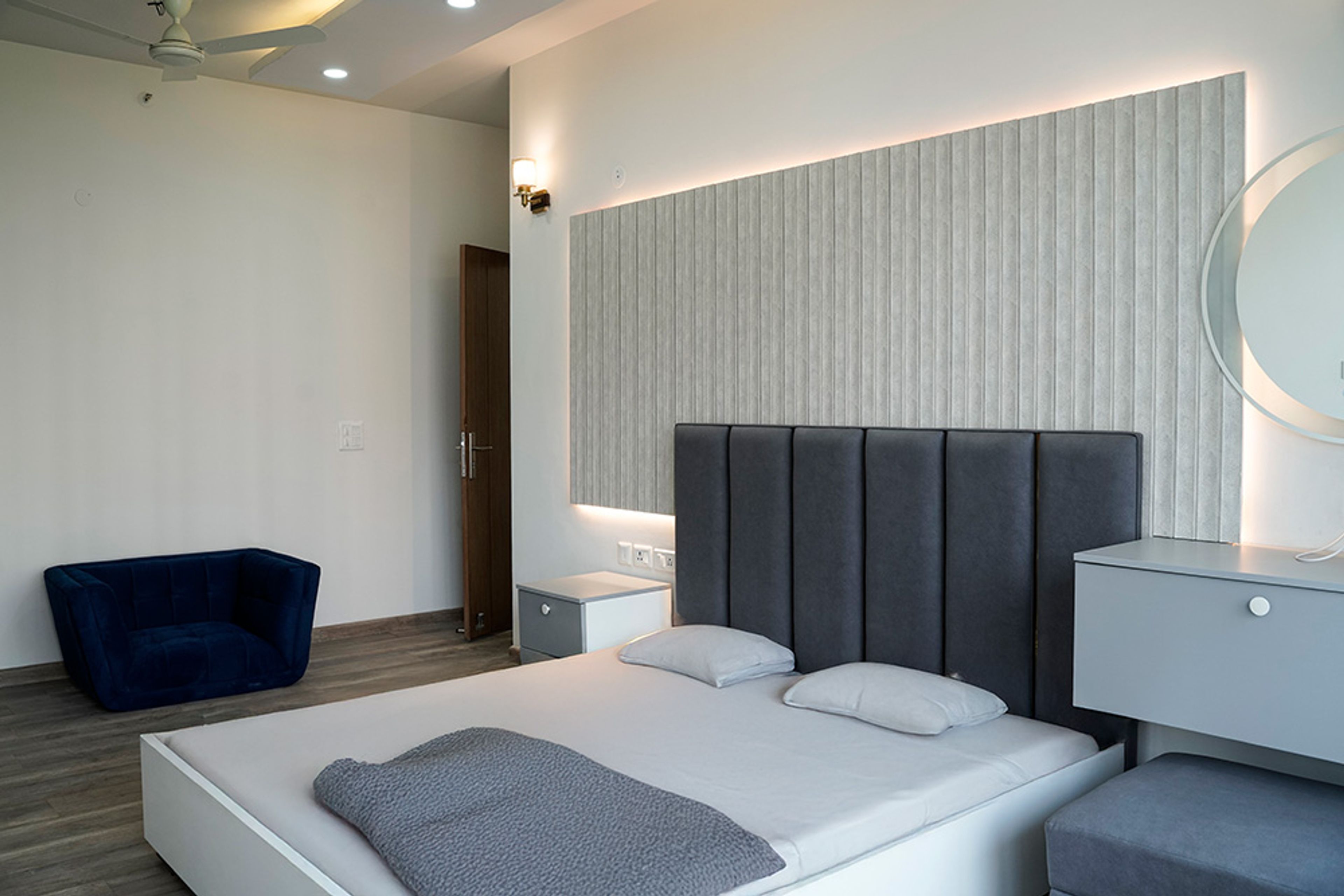 Bedroom Design with Tufted Blue Headboard Bed and Textured White Headboard Wall