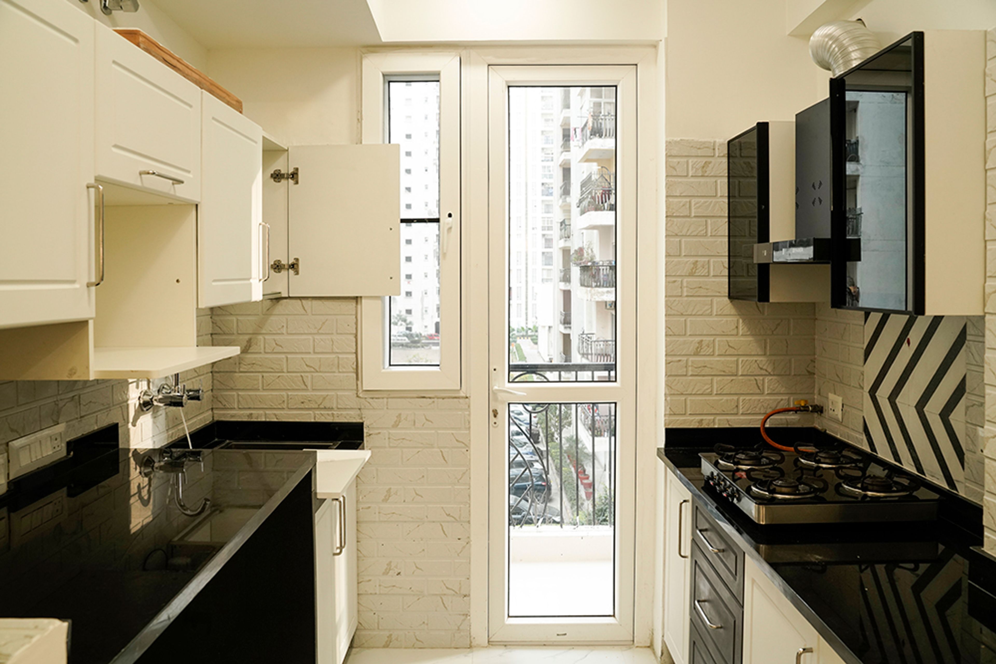 Parallel Kitchen Design with Cream and Black Units and Brock Pattenred Cream Backsplash