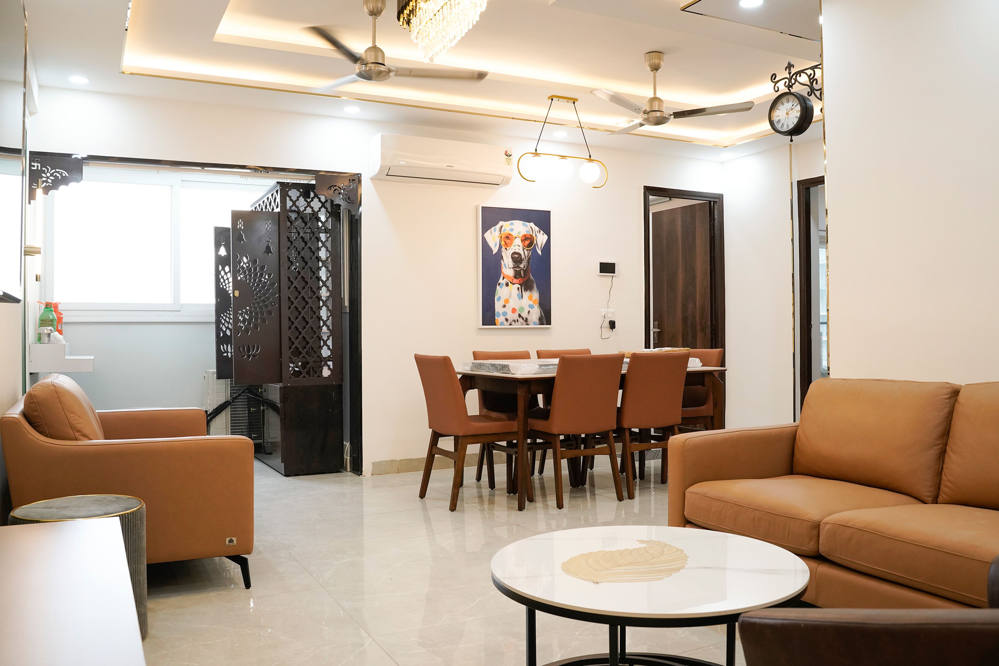 Living-cum-dining room with brown sofa and wooden pooja unit