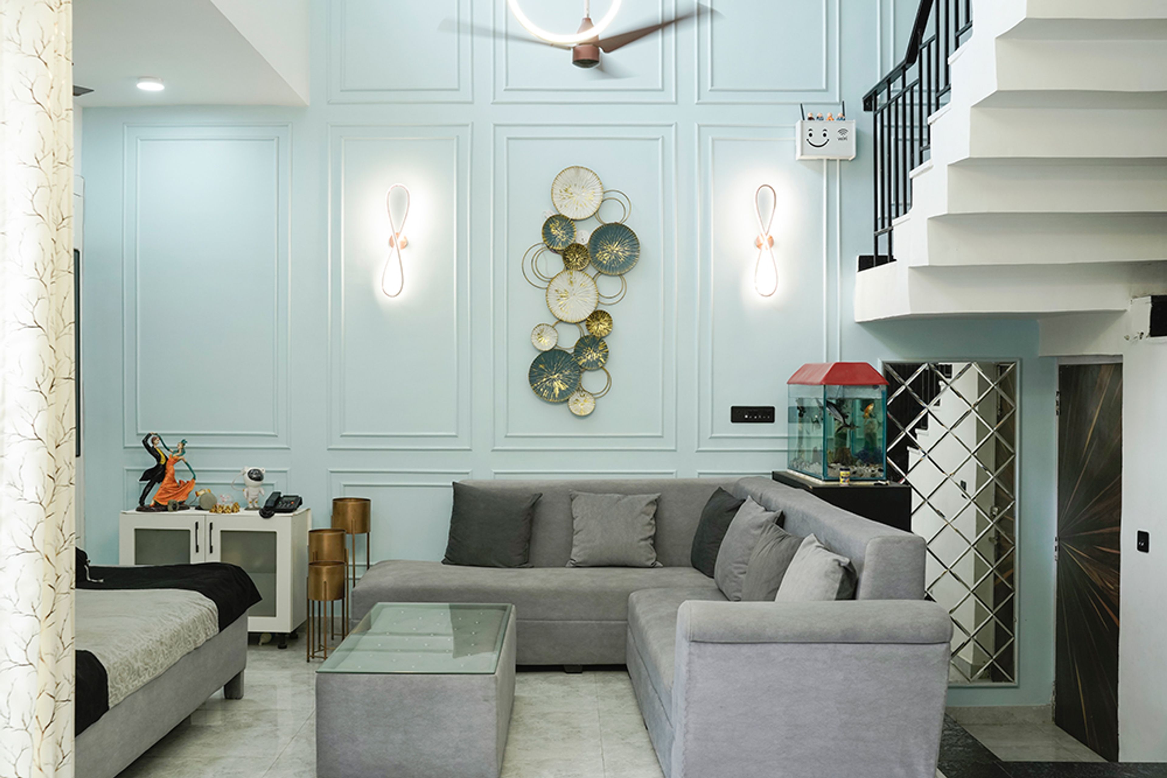 Living Room Design with Grey Sofa Set and Blue Accent Wall with Gold Metal Wall Art