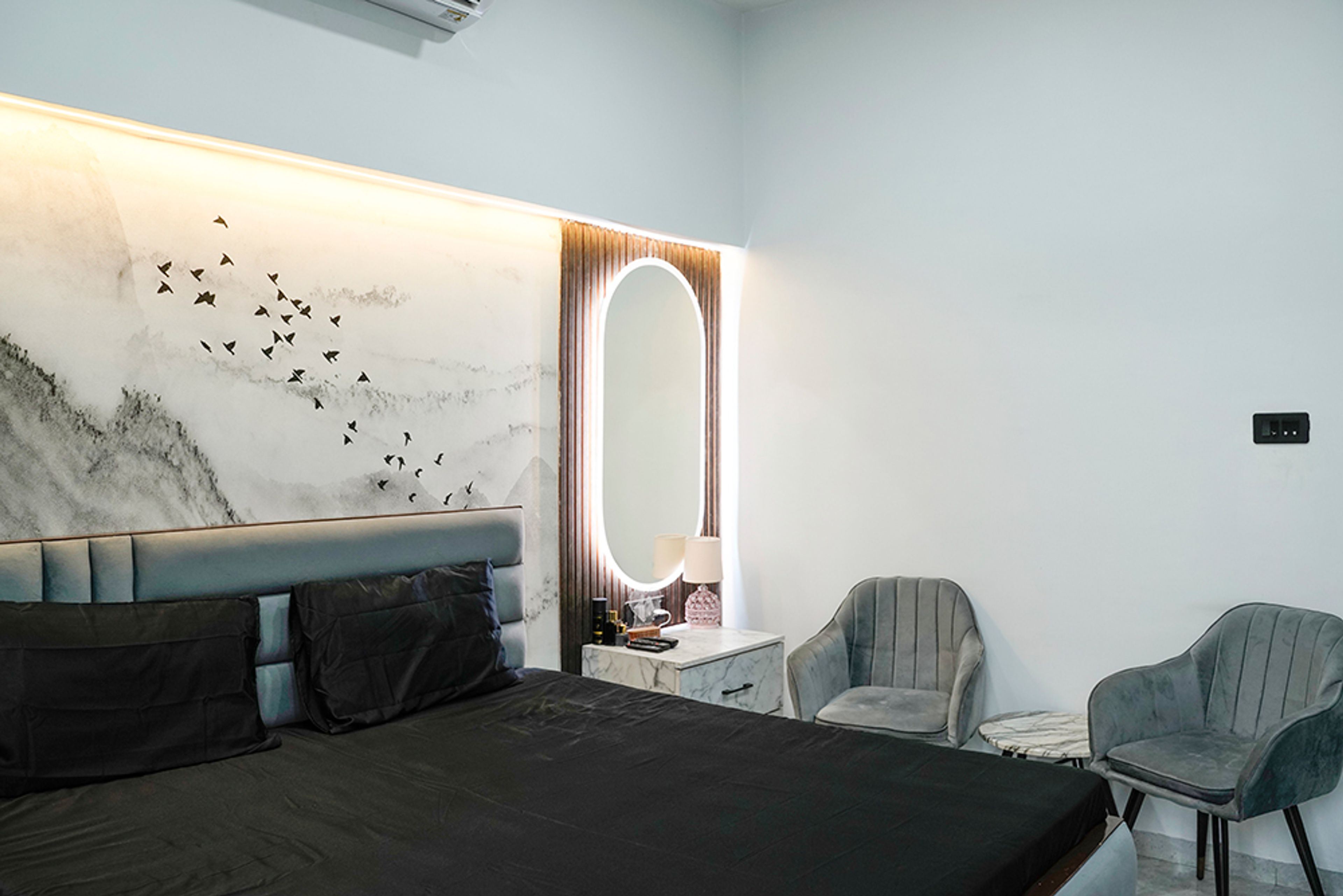 Master Bedroom Design with Oval Mirror Dressing Unit and Two Grey Velvet Chairs