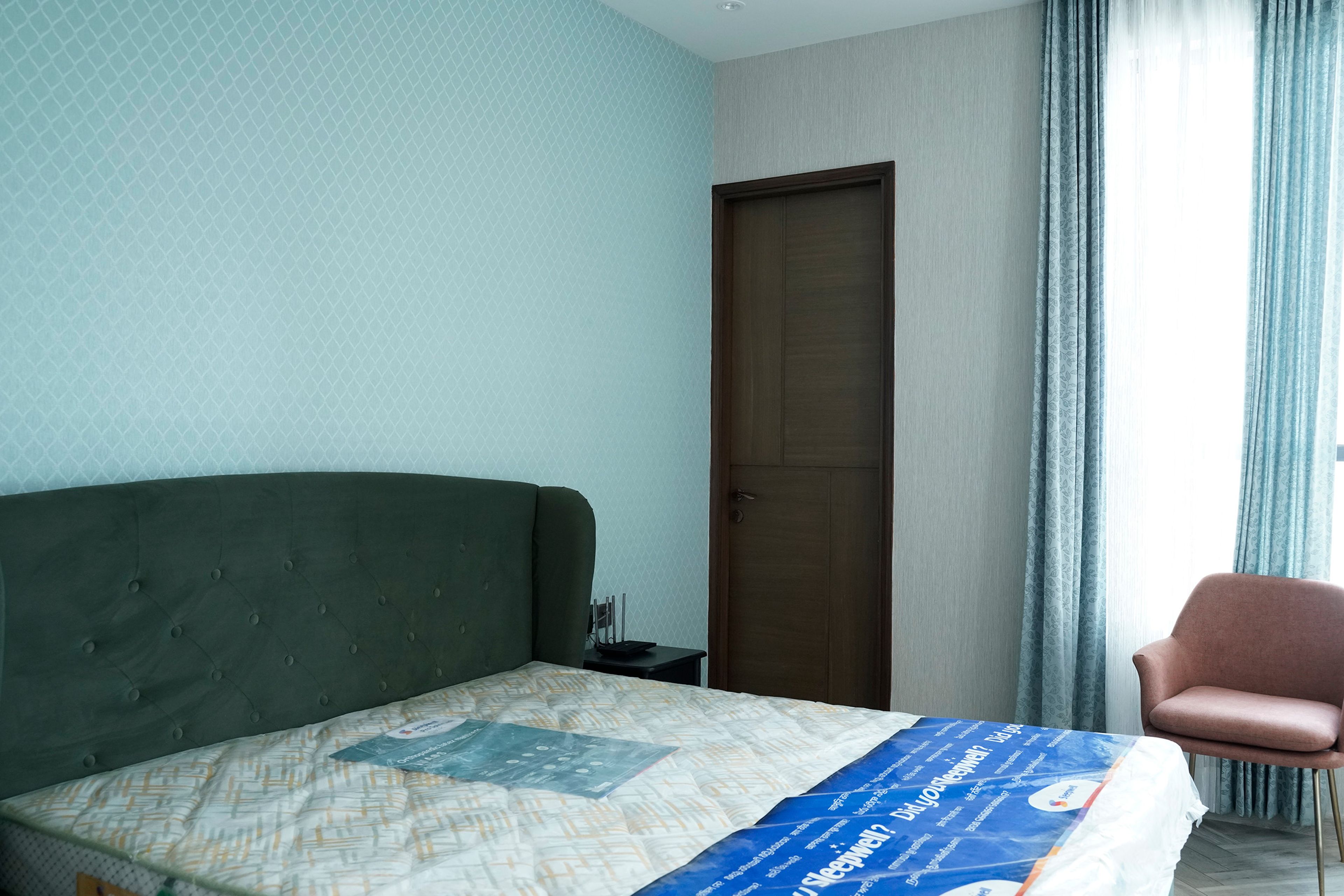 Bedroom Design with Blue Geometric Print Wallpaper and Dark Green Tufted Headboard Bed