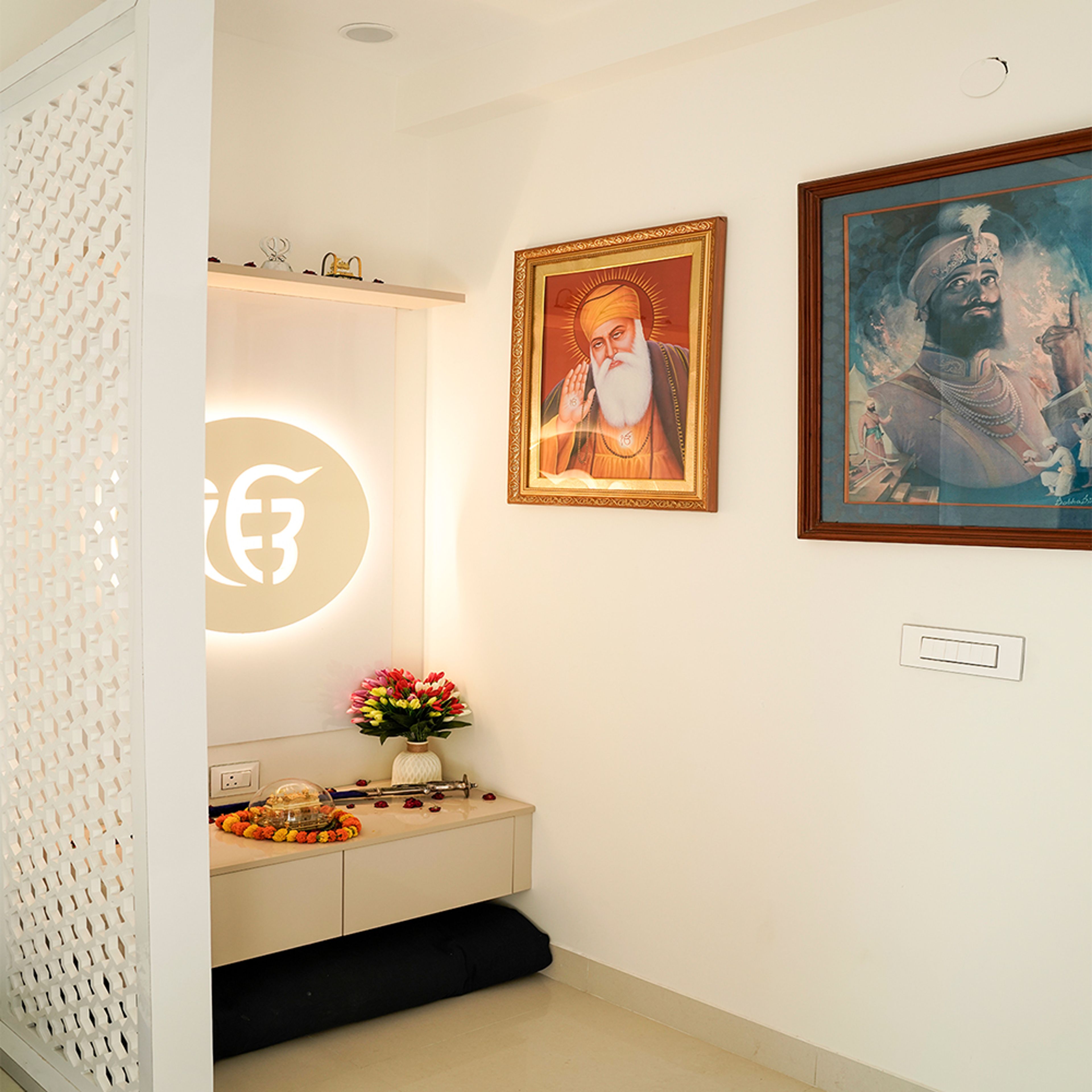 Pooja Room With Backlit Religious Symbol, Decorative Jaali Partition, Wall Art, and Floating Cabinet
