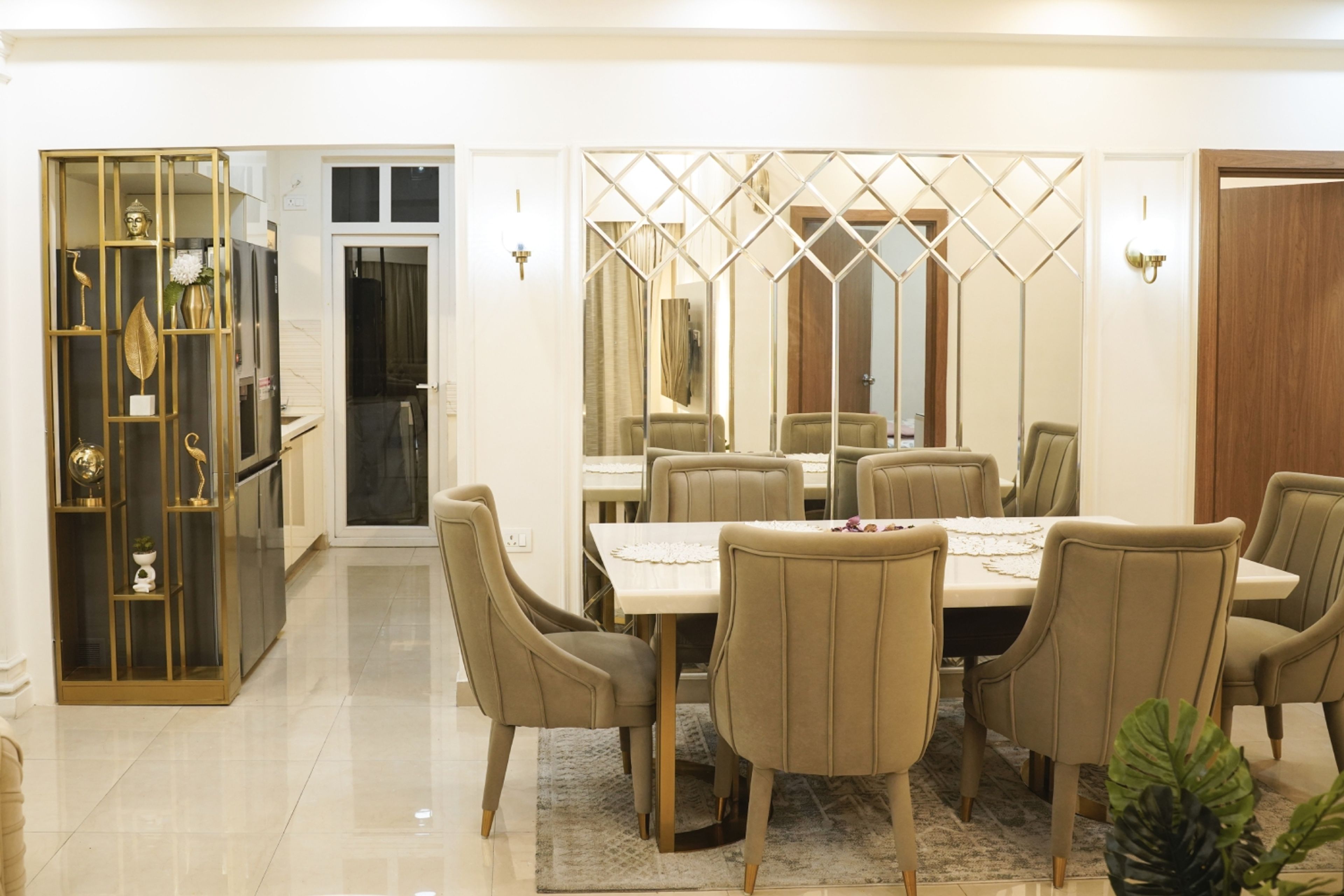 Dining Room Design with Beige Chairs, Mirrored Wall Panels, and Golden Metal Display Shelf