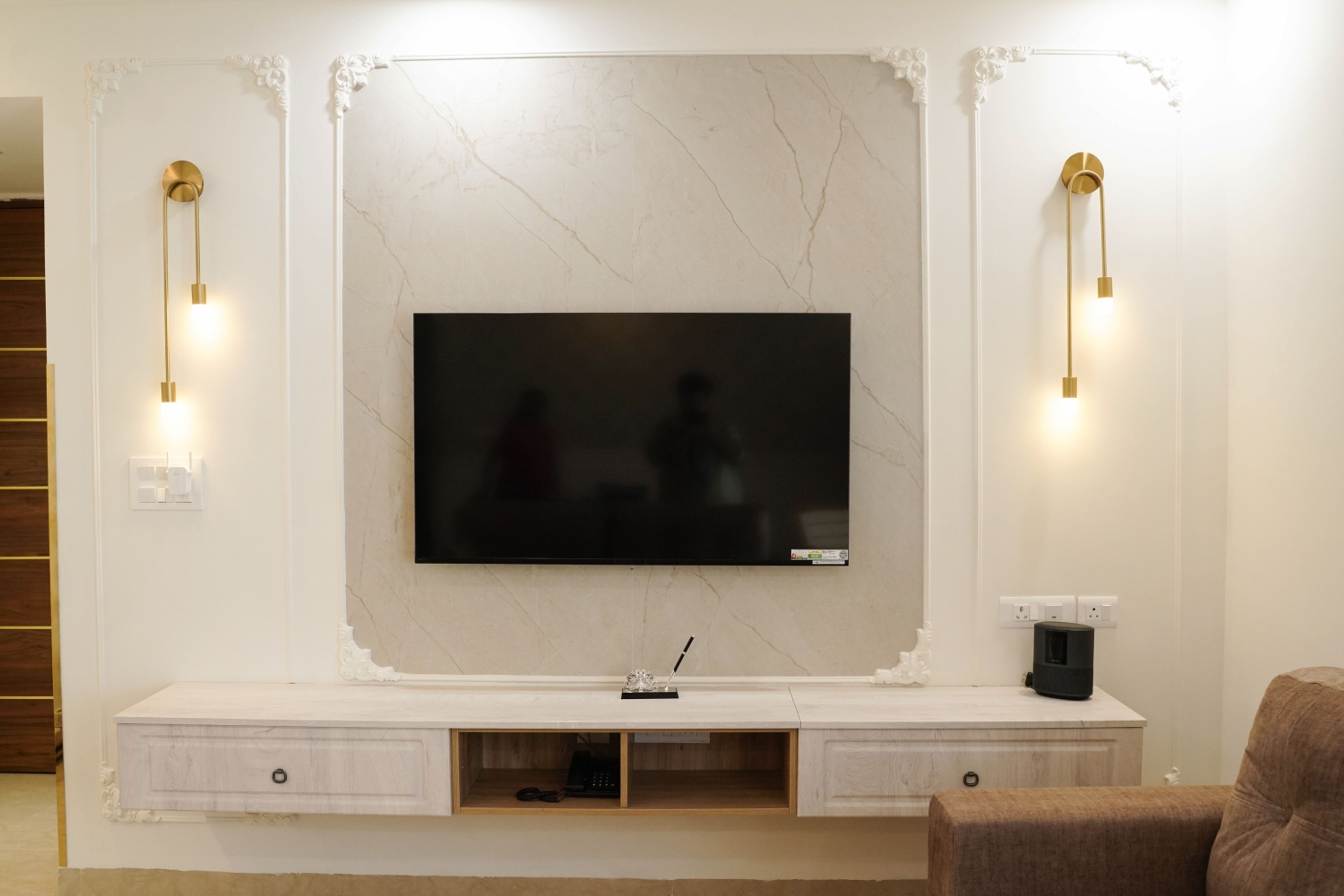 White TV Unit Design with White Wall Moulding and Brass Wall Lights