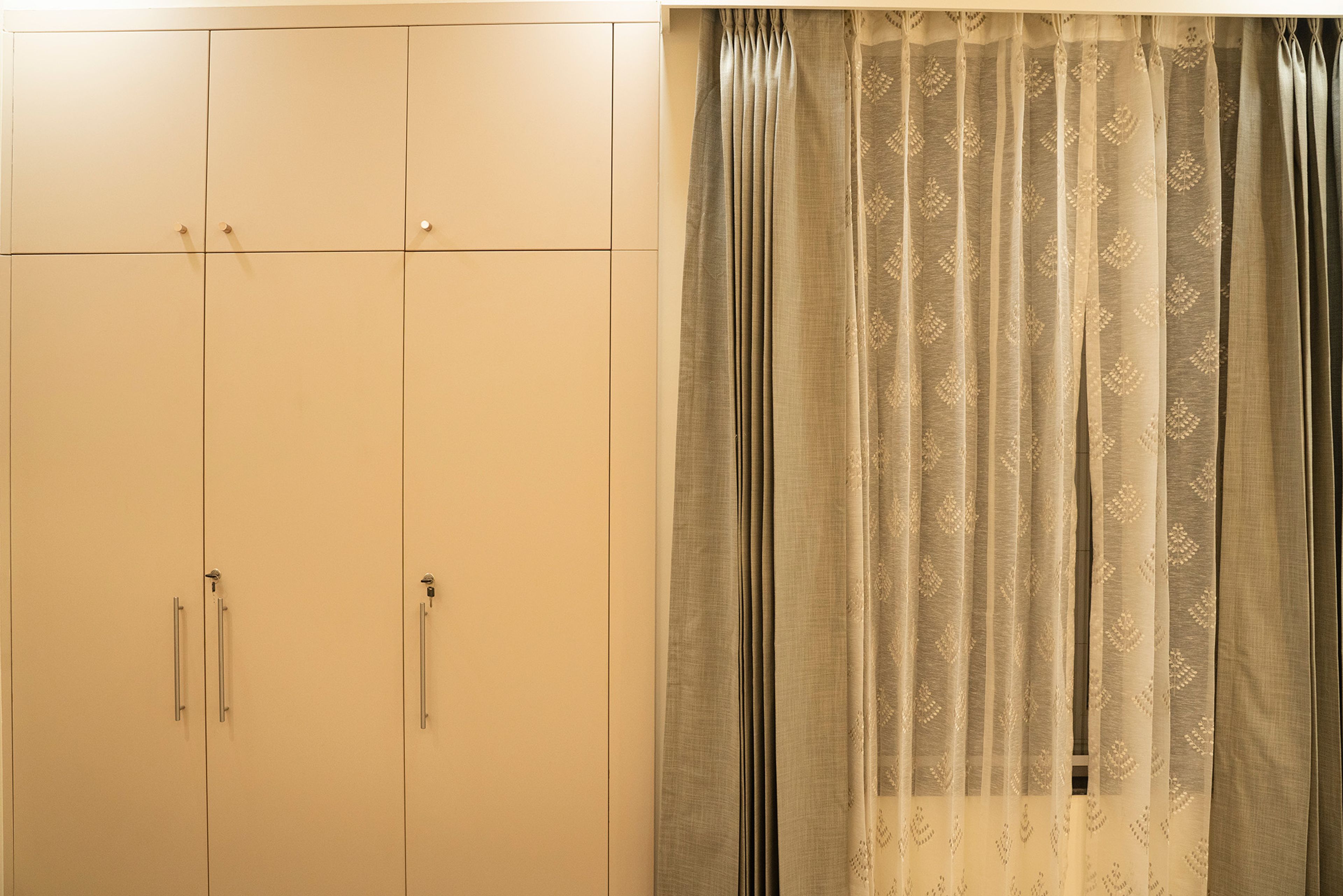 Bedroom design with beige 3-door swing wardrobe