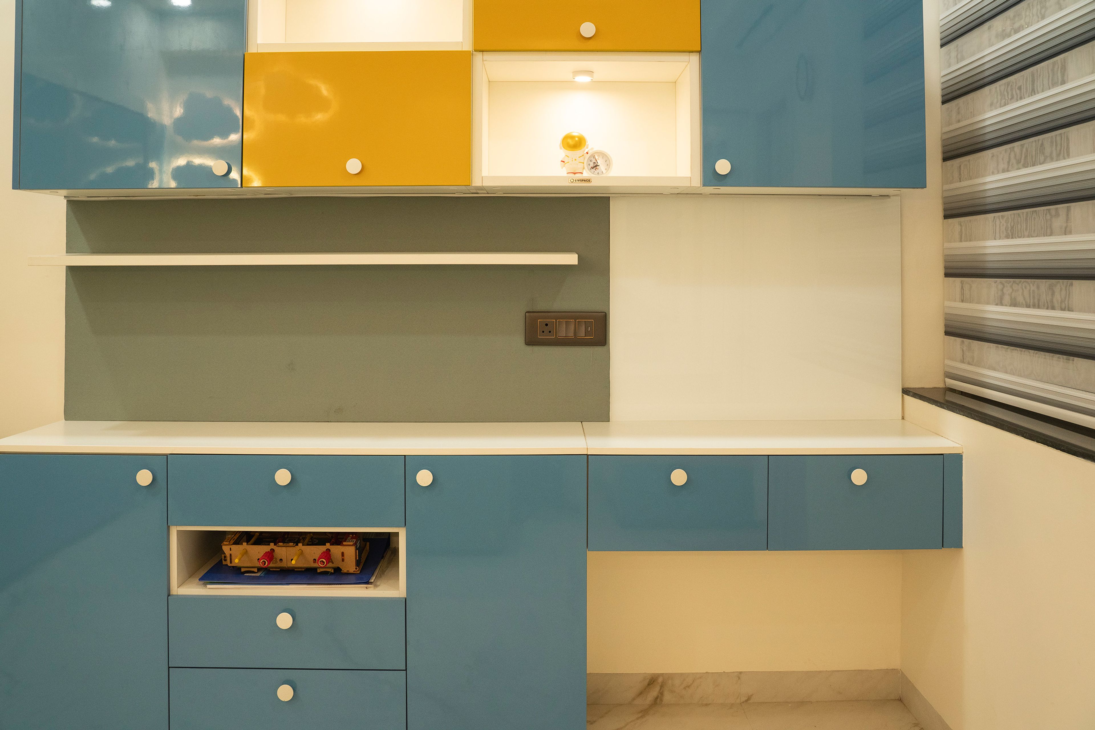 Study space with wall mounted cabinets in white, blue and yellow
