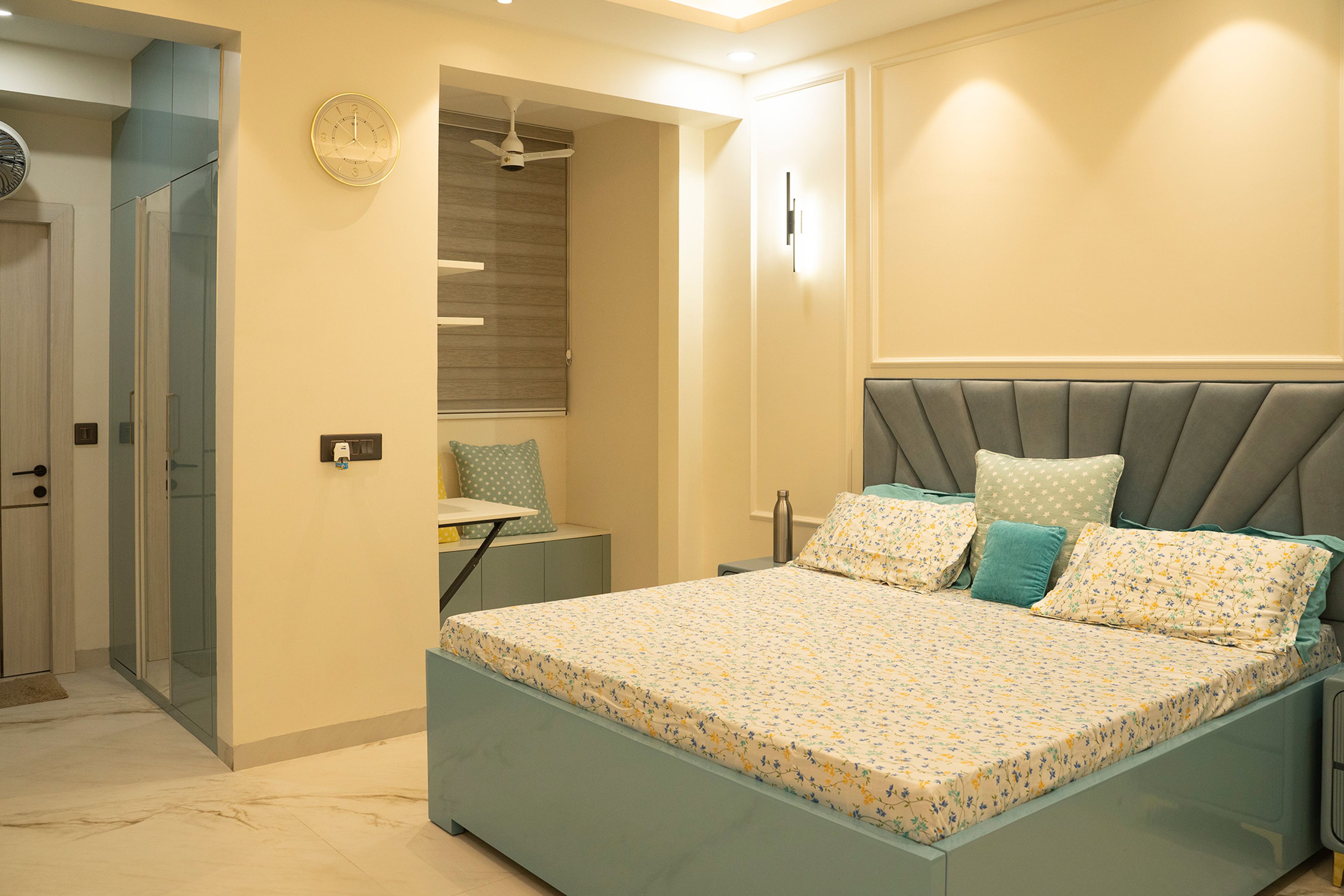 Bedroom design with blue cushioned headboard bed and study desk