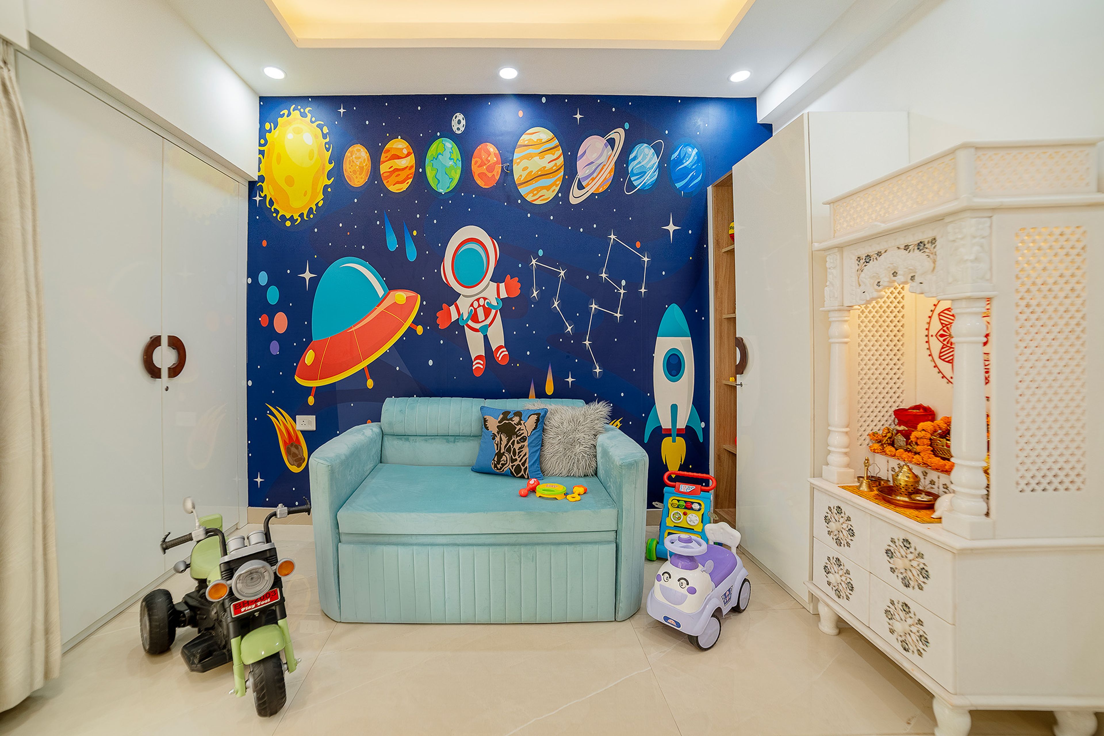 Kids Bedroom Design with Space and Astronaut Themed Wallpaper, Blue 2-Seater Sofa Cum Bed and White Pooja Unit