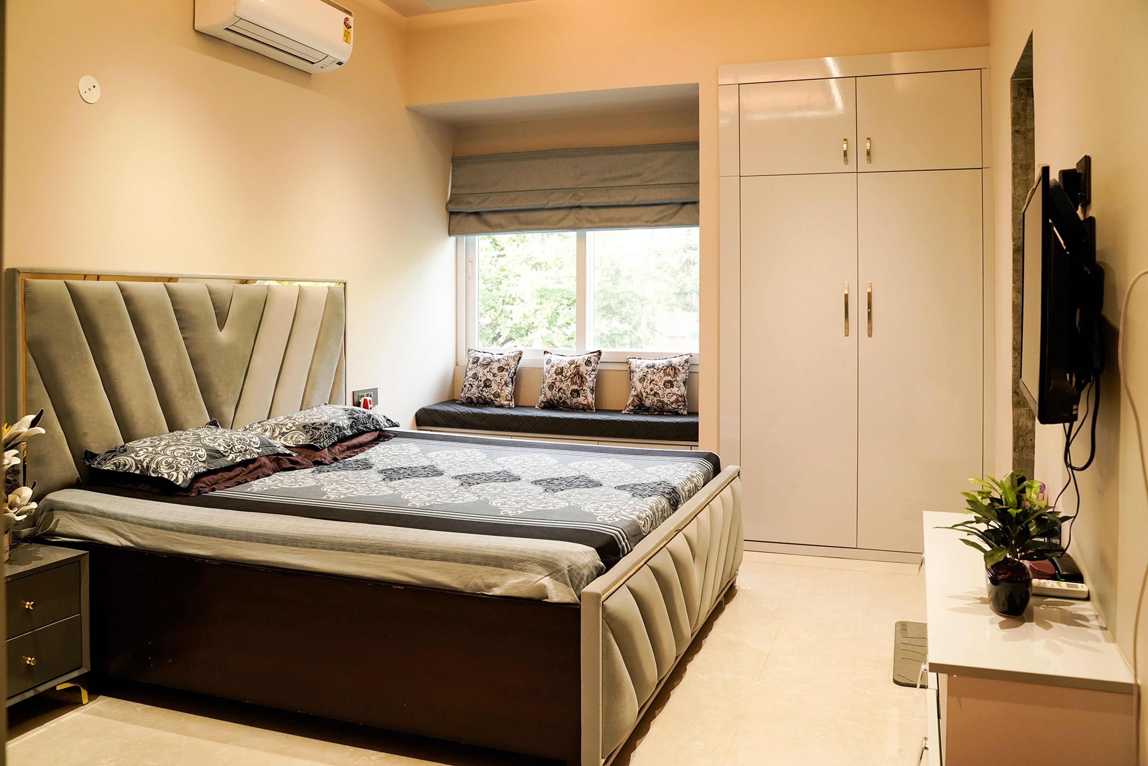 Bedroom design with green cushioned headboard bed and 2-door cream swing wardrobe