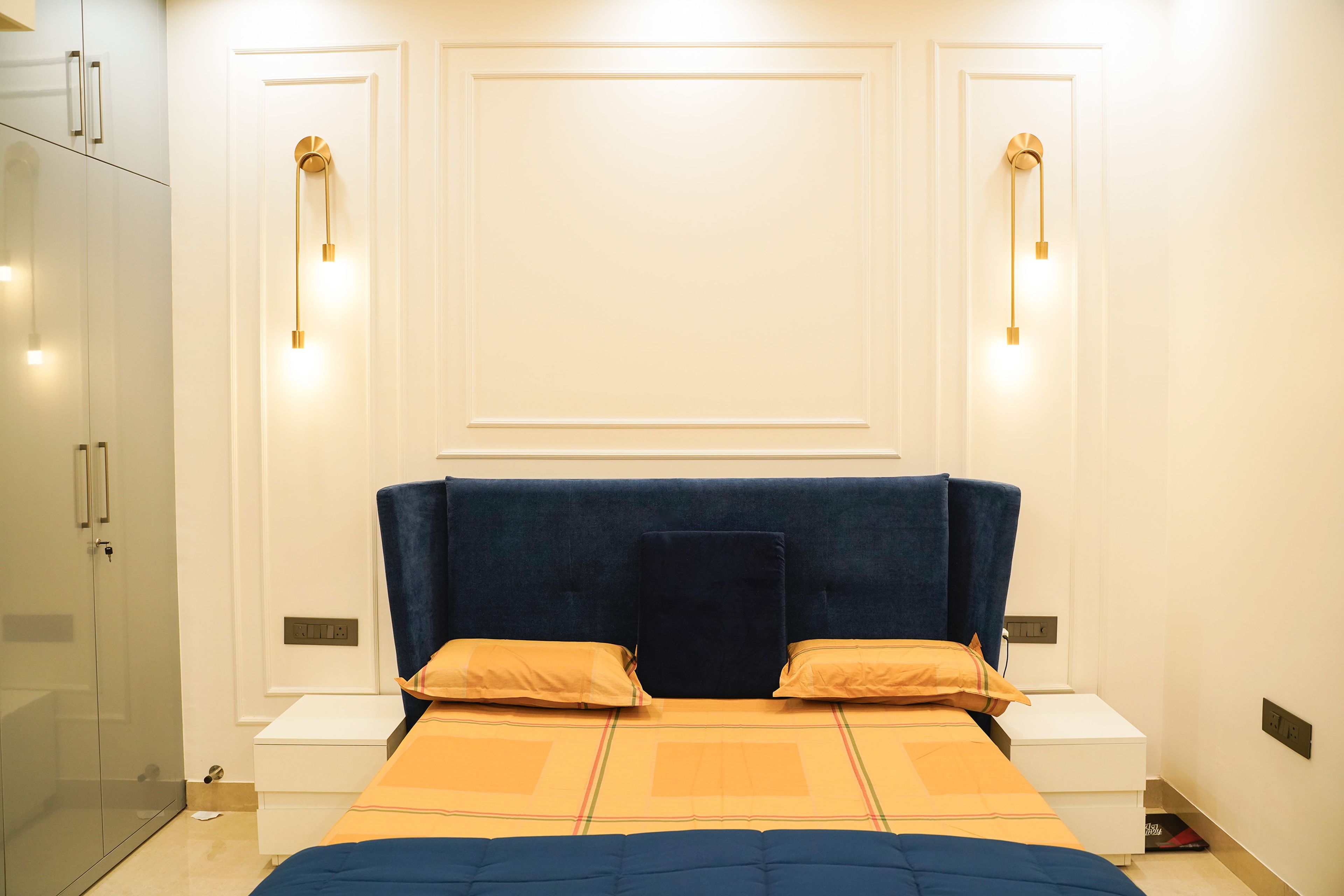 Master Bedroom Design with Blue Wingback Headboard, White Wall Trims, and Pendant Lights