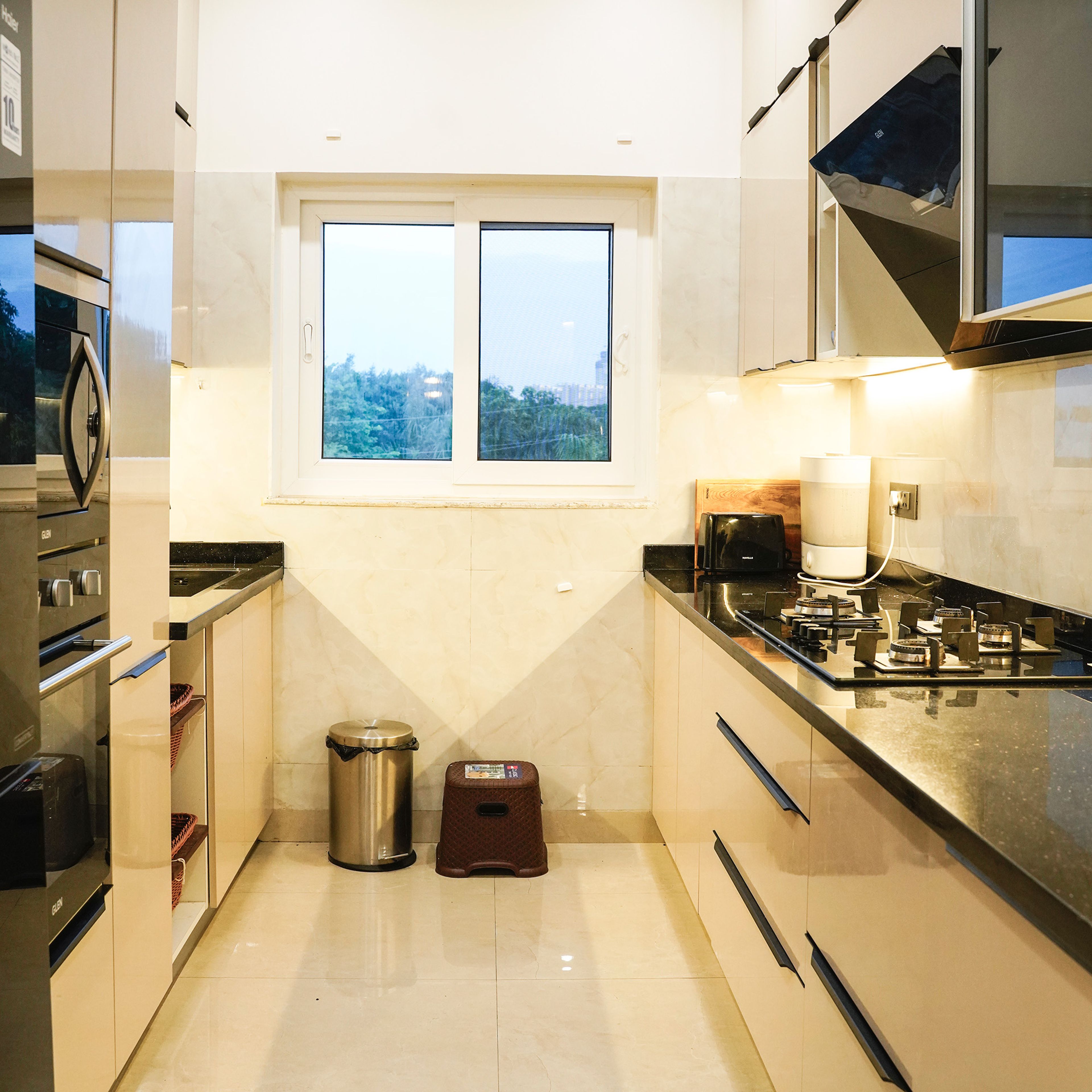 Parallel Kitchen Design with Beige Cabinets, Black Granite Countertop, and Large Window
