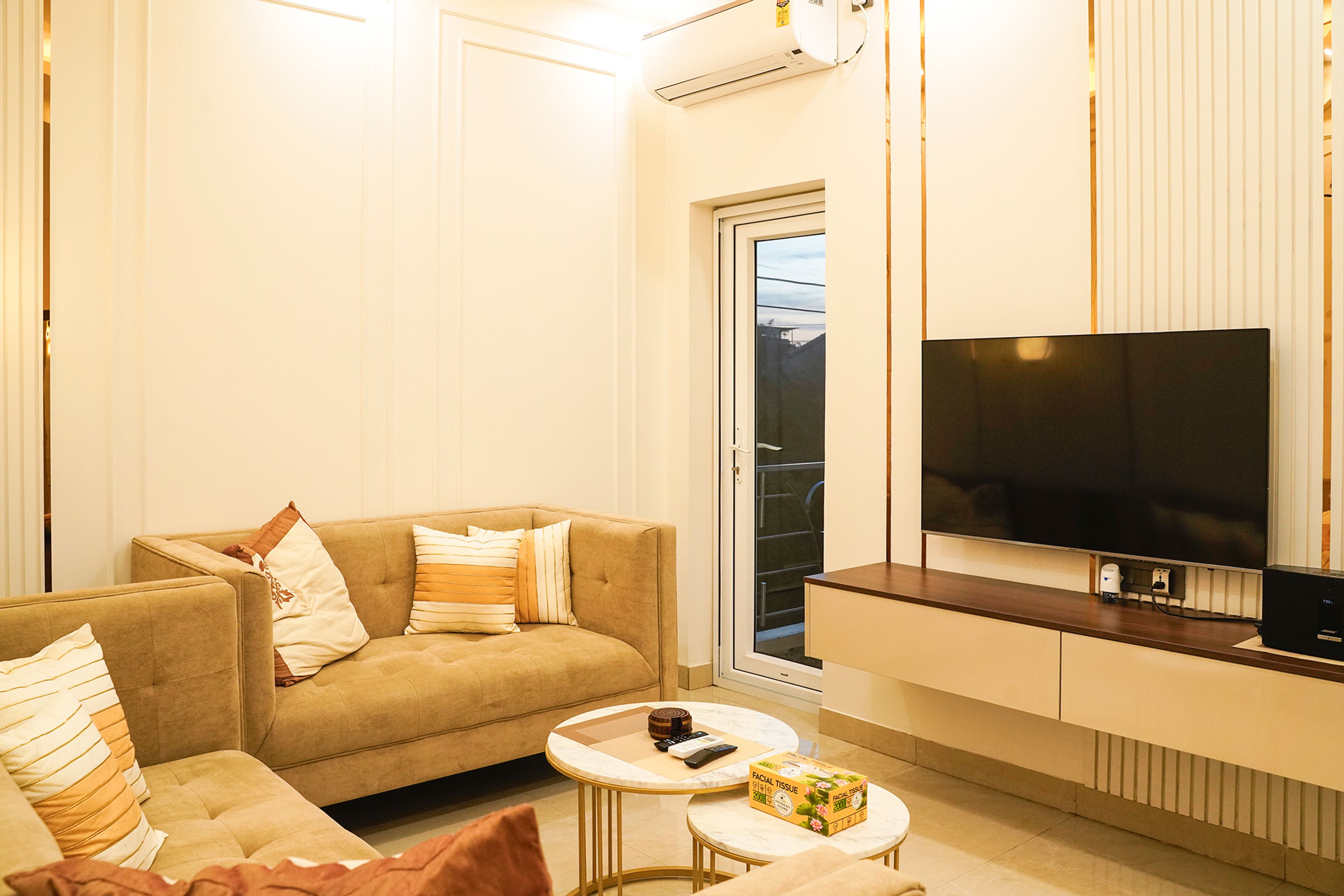 Living Room Design with Beige Sofas, Mounted TV Unit with Floating Drawer, and White Wall Trims