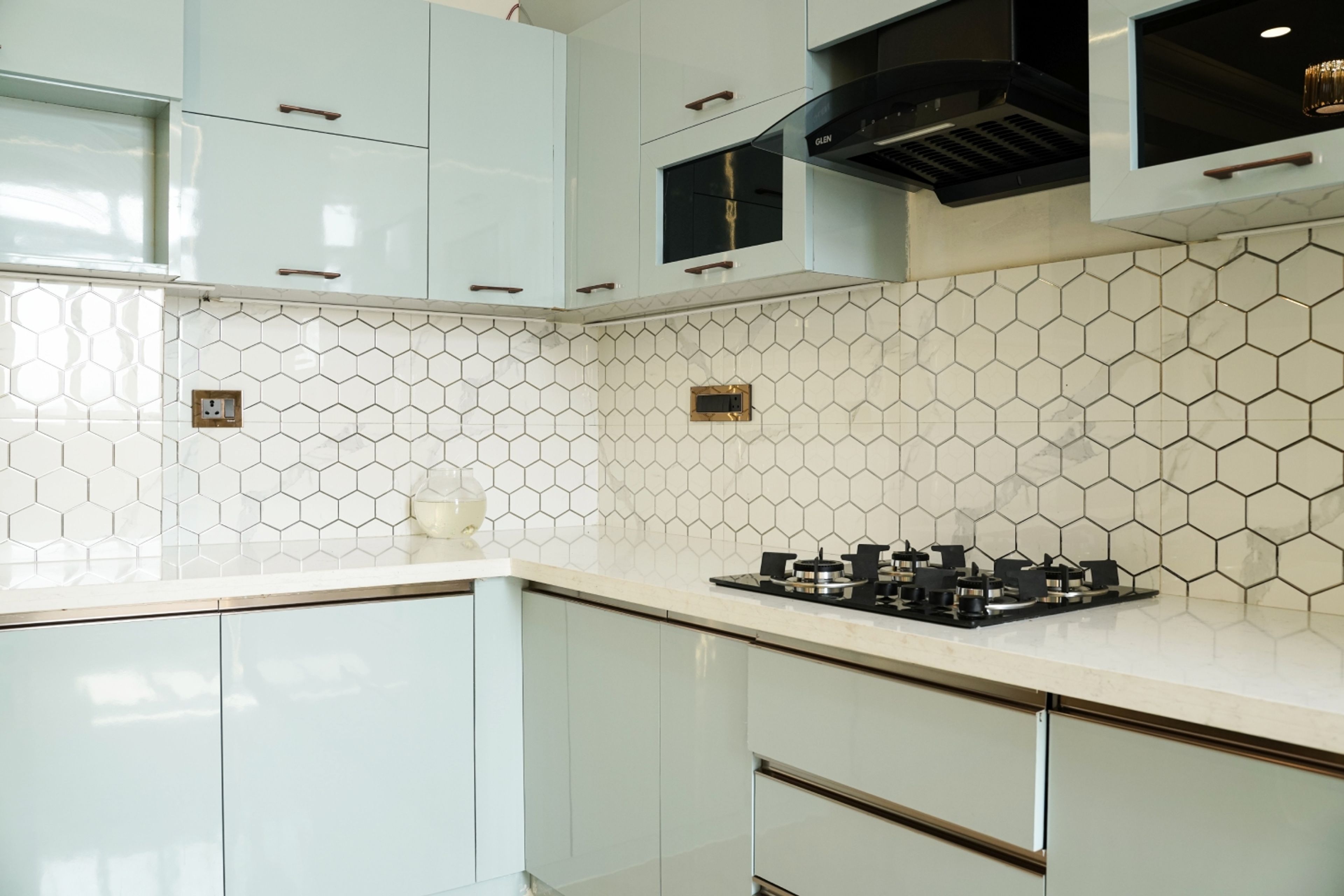 L-shaped kitchen design with white and black geometric pattern tiles backsplash