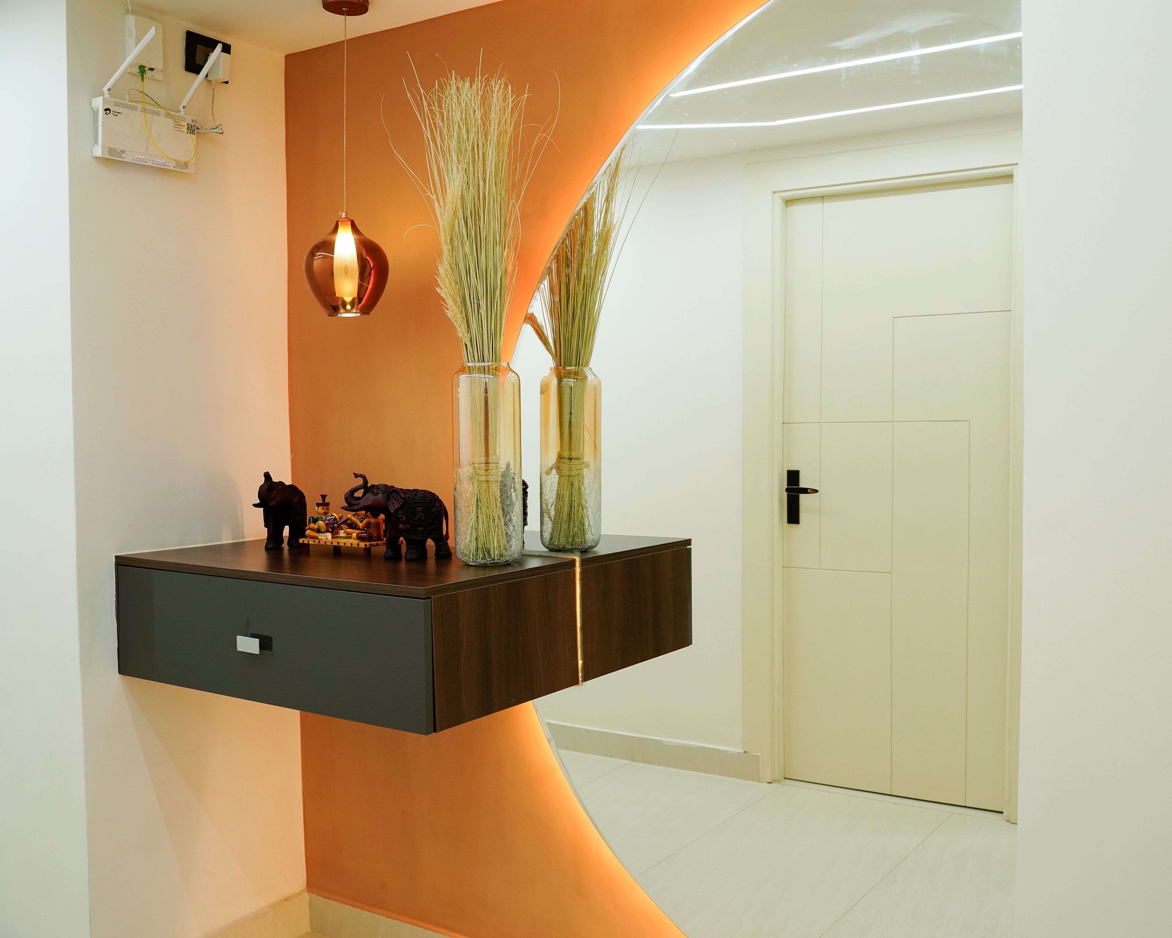 Foyer Design with Floating Dark Wooden Drawer, Orange Accent Wall, and Hanging Pendant Light