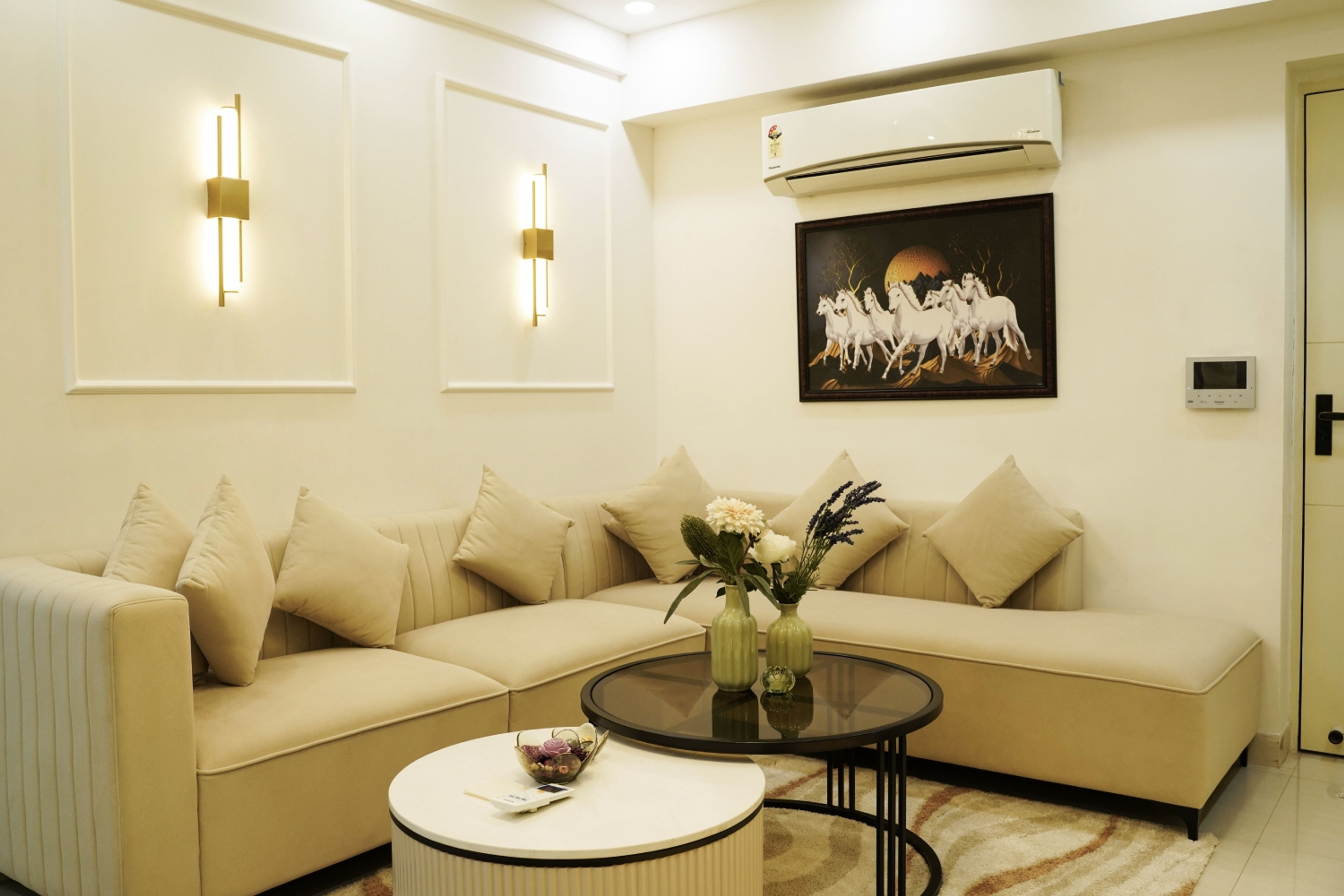 Living Room Design with Beige Sectional Sofa, White Wall Trims, and Golden Wall Sconces