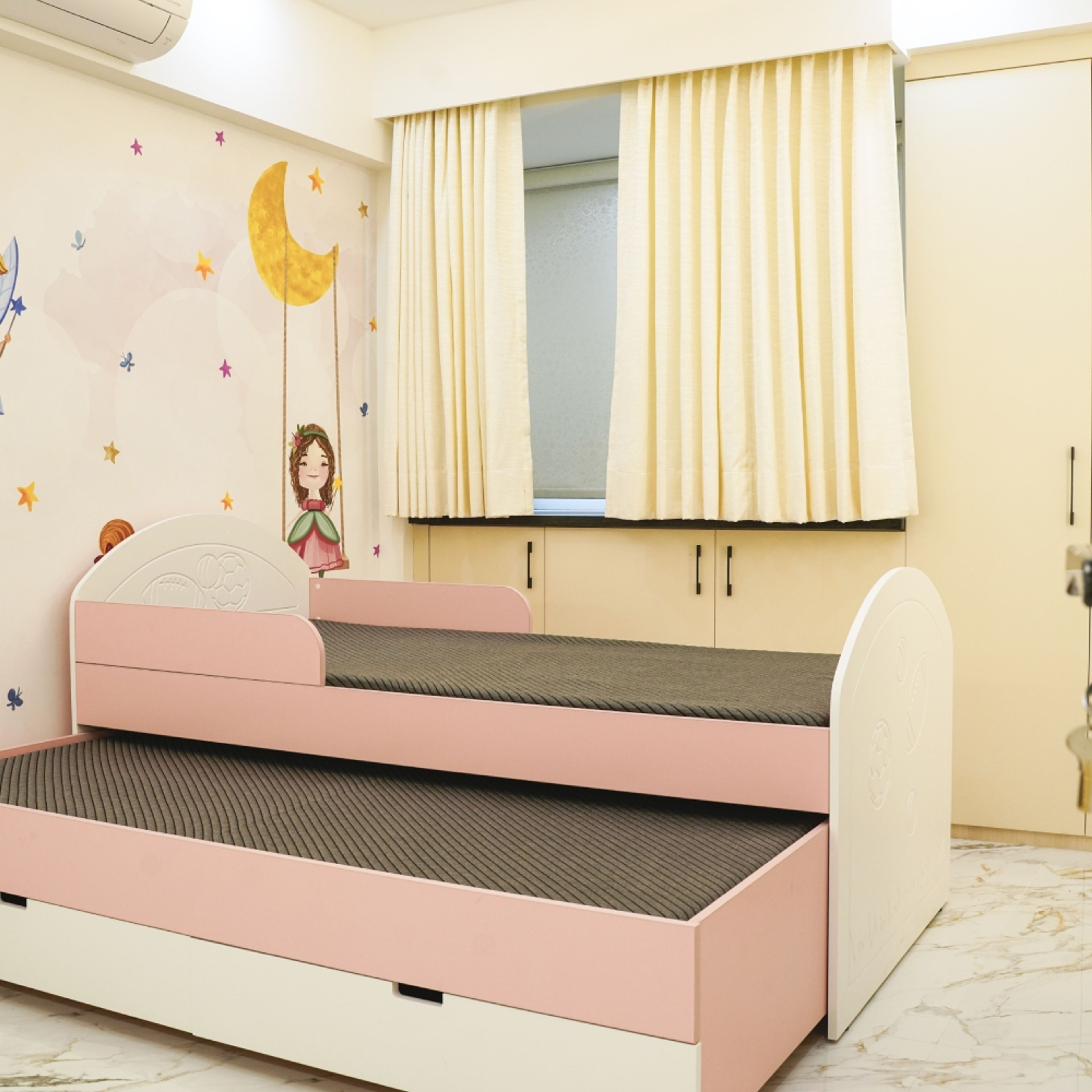 Kids Bedroom Design with Pink and White Pull-Out Bed, Moon Wall Art, and Cream Wardrobe