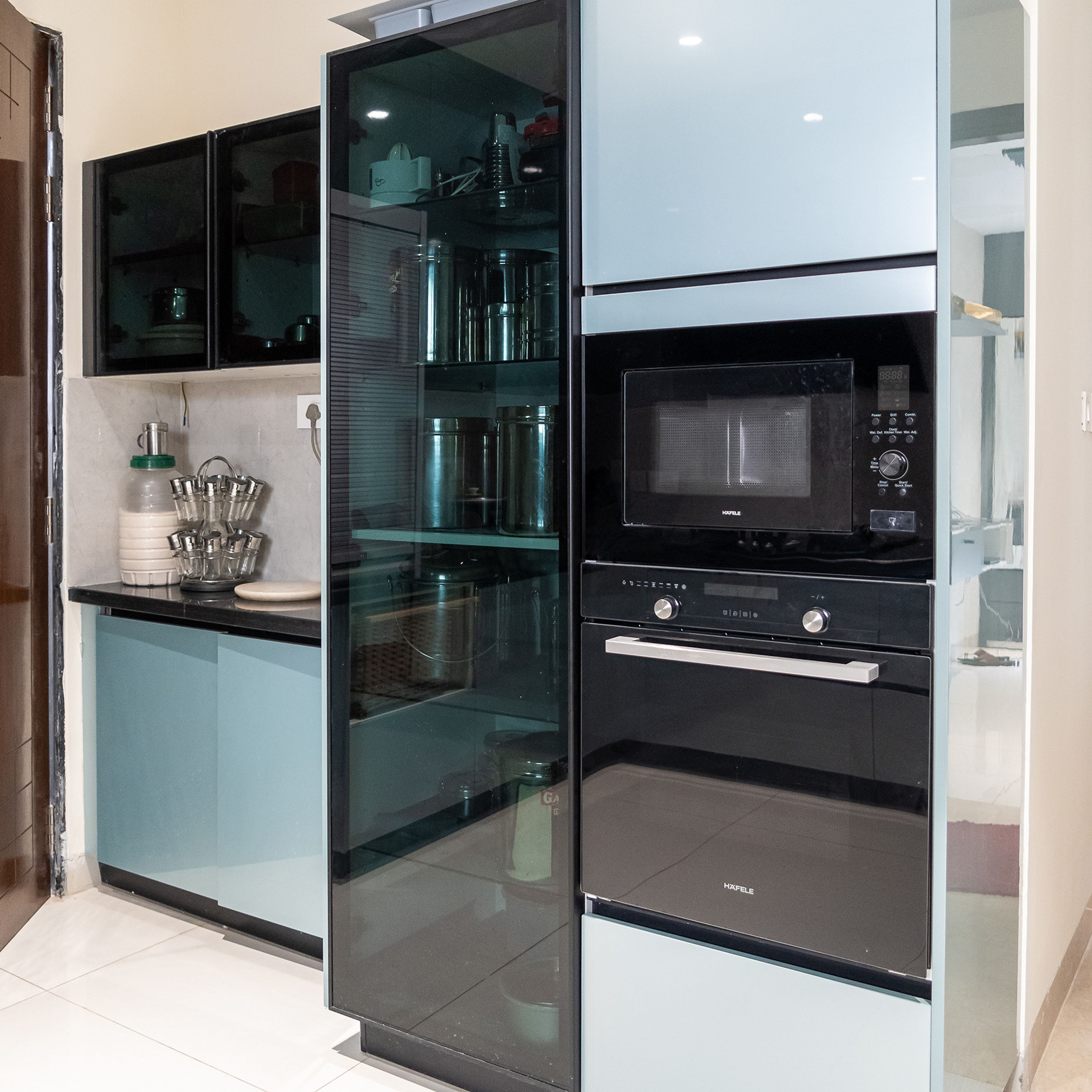 Tall Kitchen Unit Design with Built-in Oven, Microwave, and Glass Cabinets