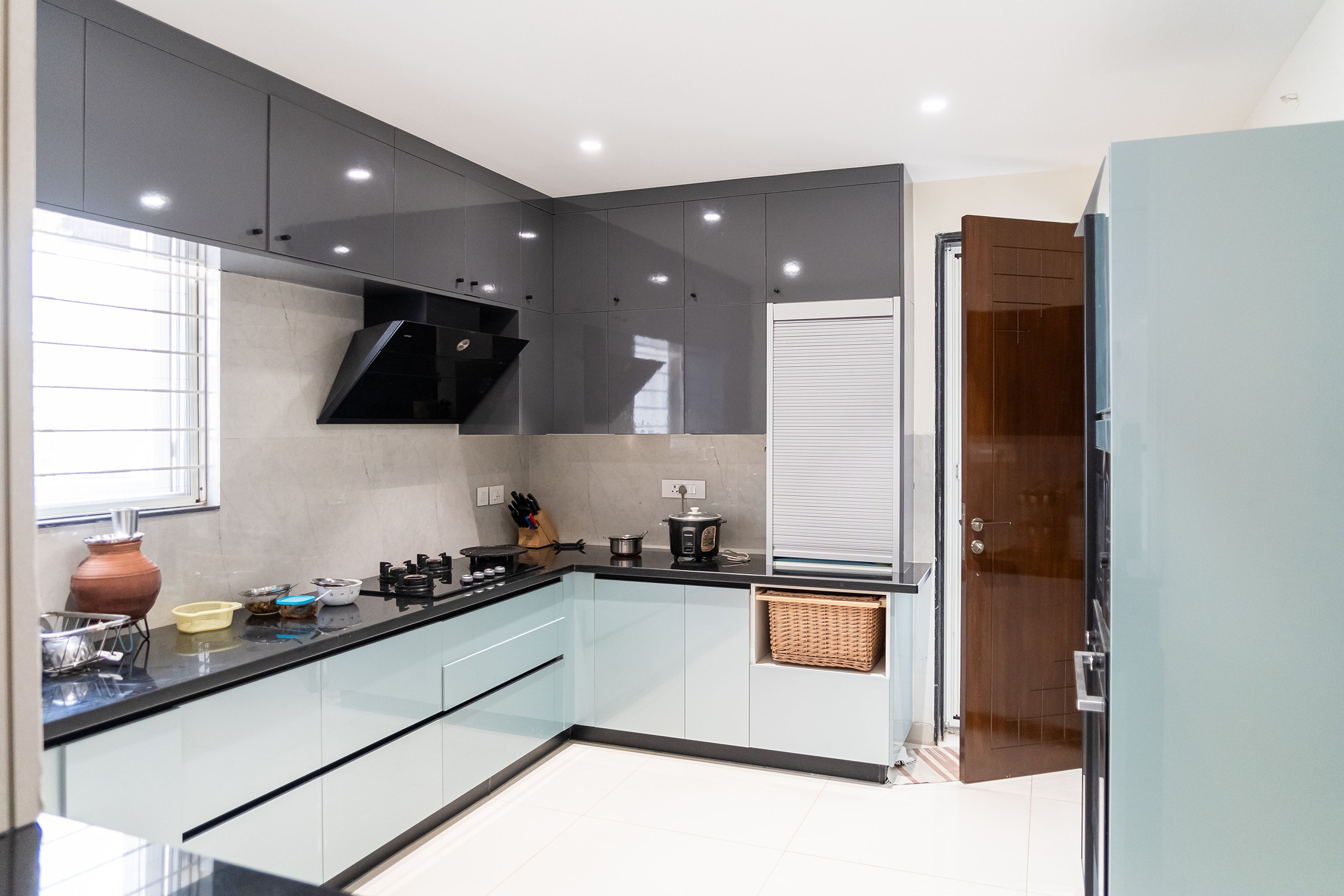 L-Shaped Kitchen Design with Grey and Mint Blue Cabinets and Black Countertop