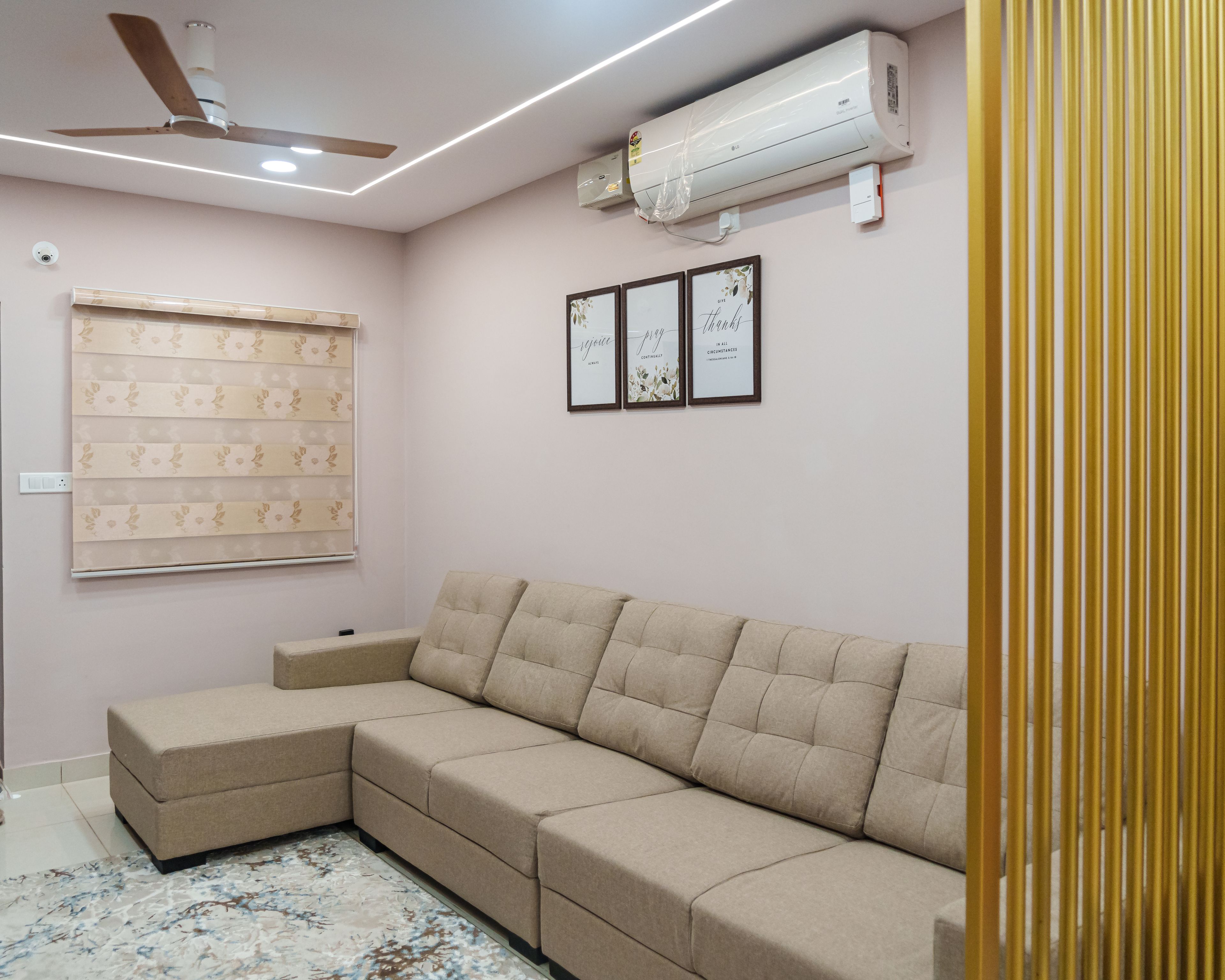 Living Room Design with Beige Sectional Sofa, Light Pink Walls, and Gold Divider