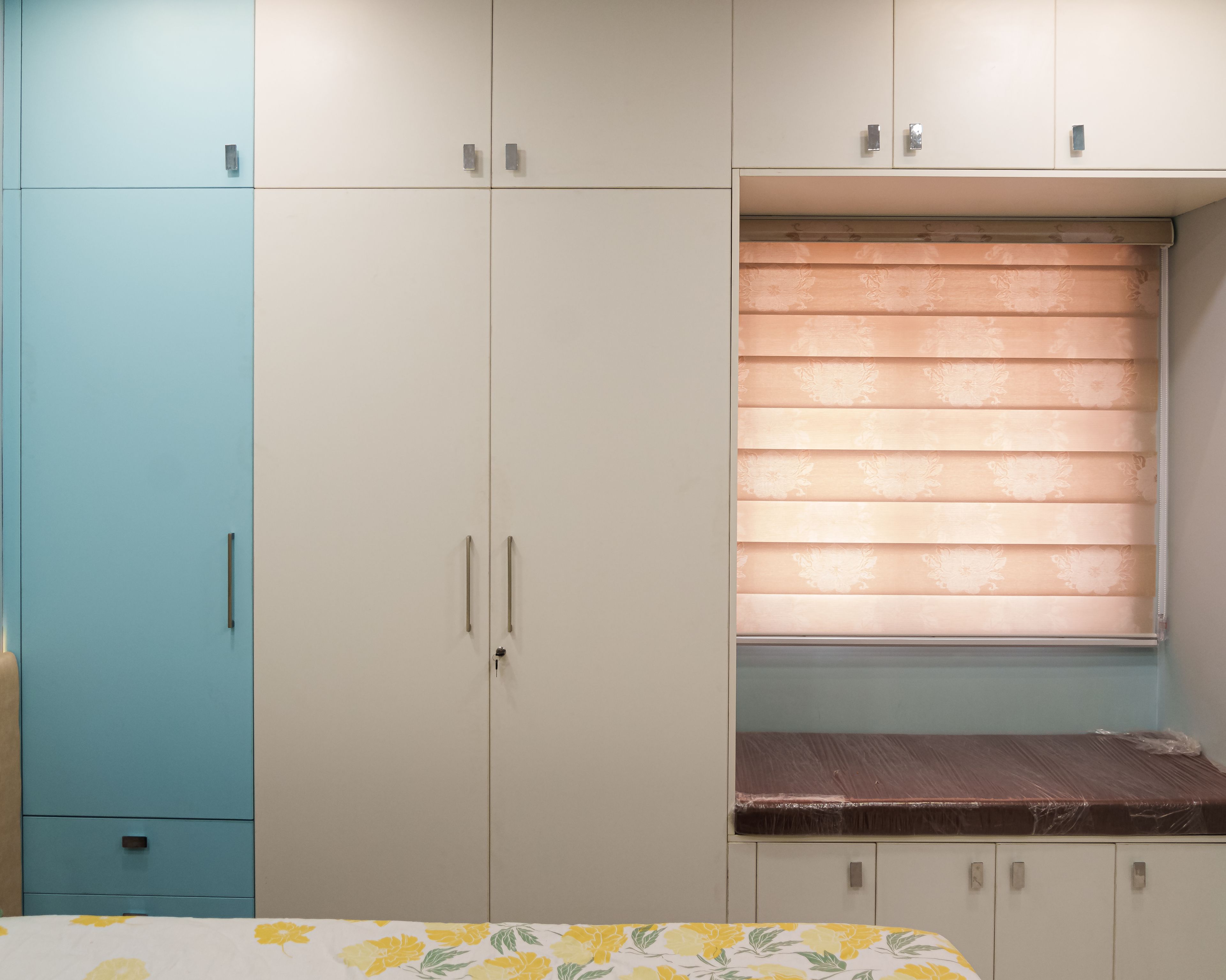 5-Door Wardrobe Design with White and Blue Cabinets and Window Seating
