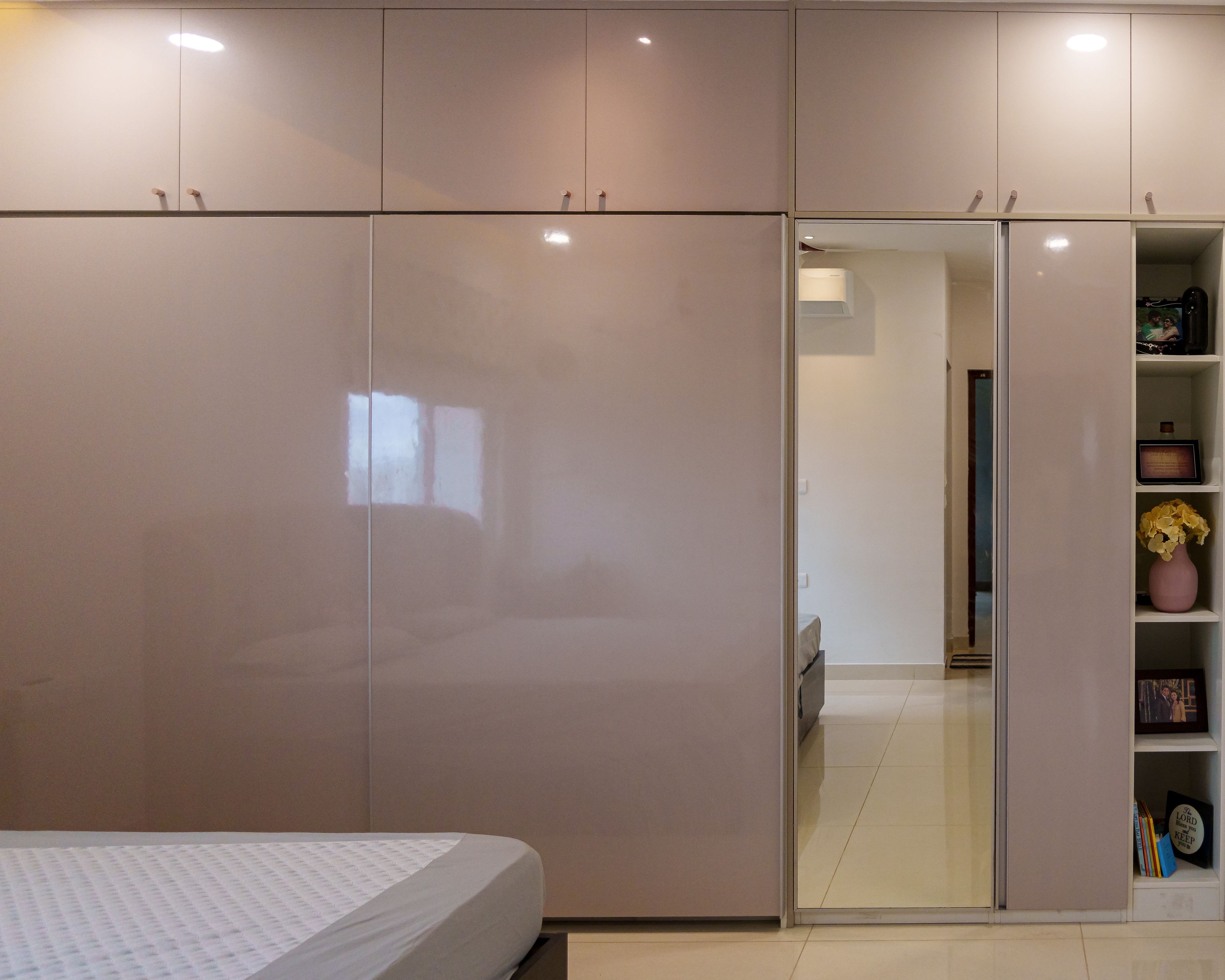 Wardrobe Design with Glossy Beige Sliding Doors, Integrated Mirror, and Open Display Shelves