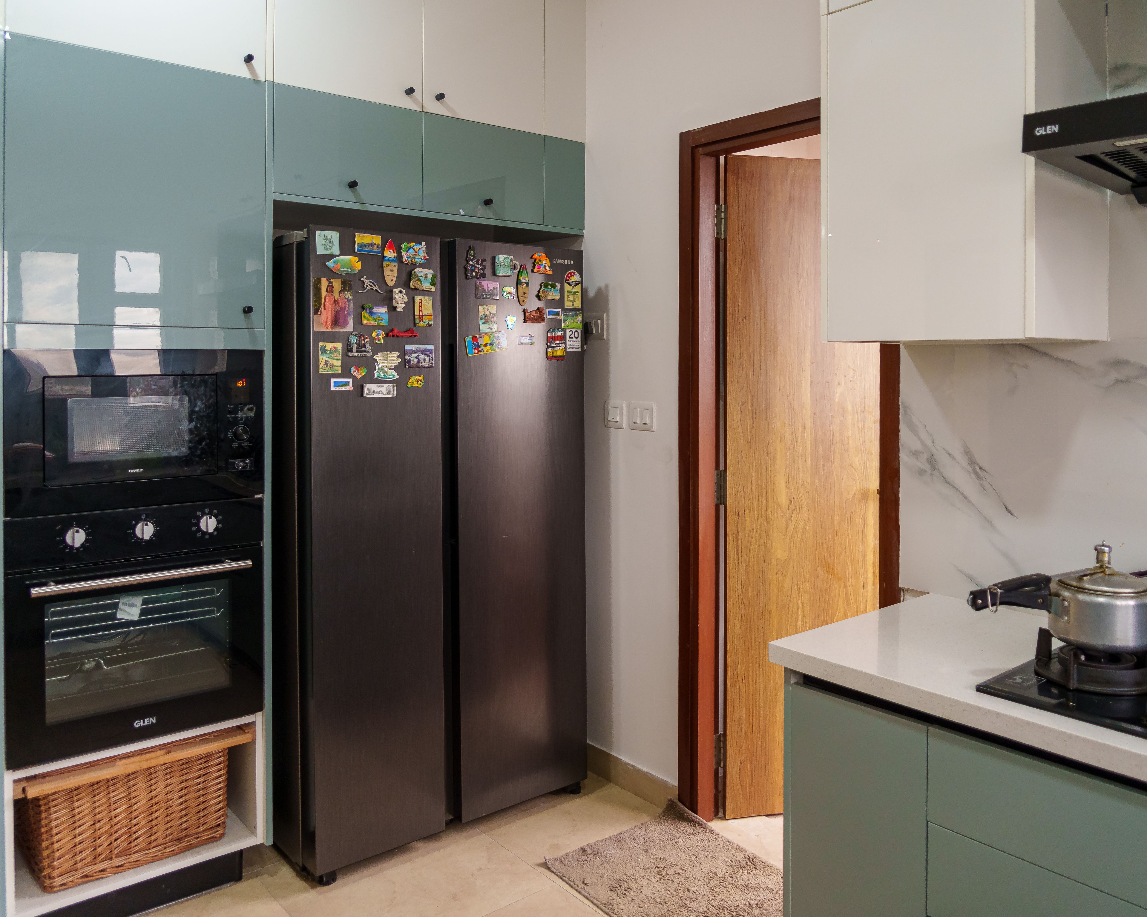 L-Shaped Kitchen Design with Green and White Cabinets, Built-in Oven, and Double Door Refrigerator