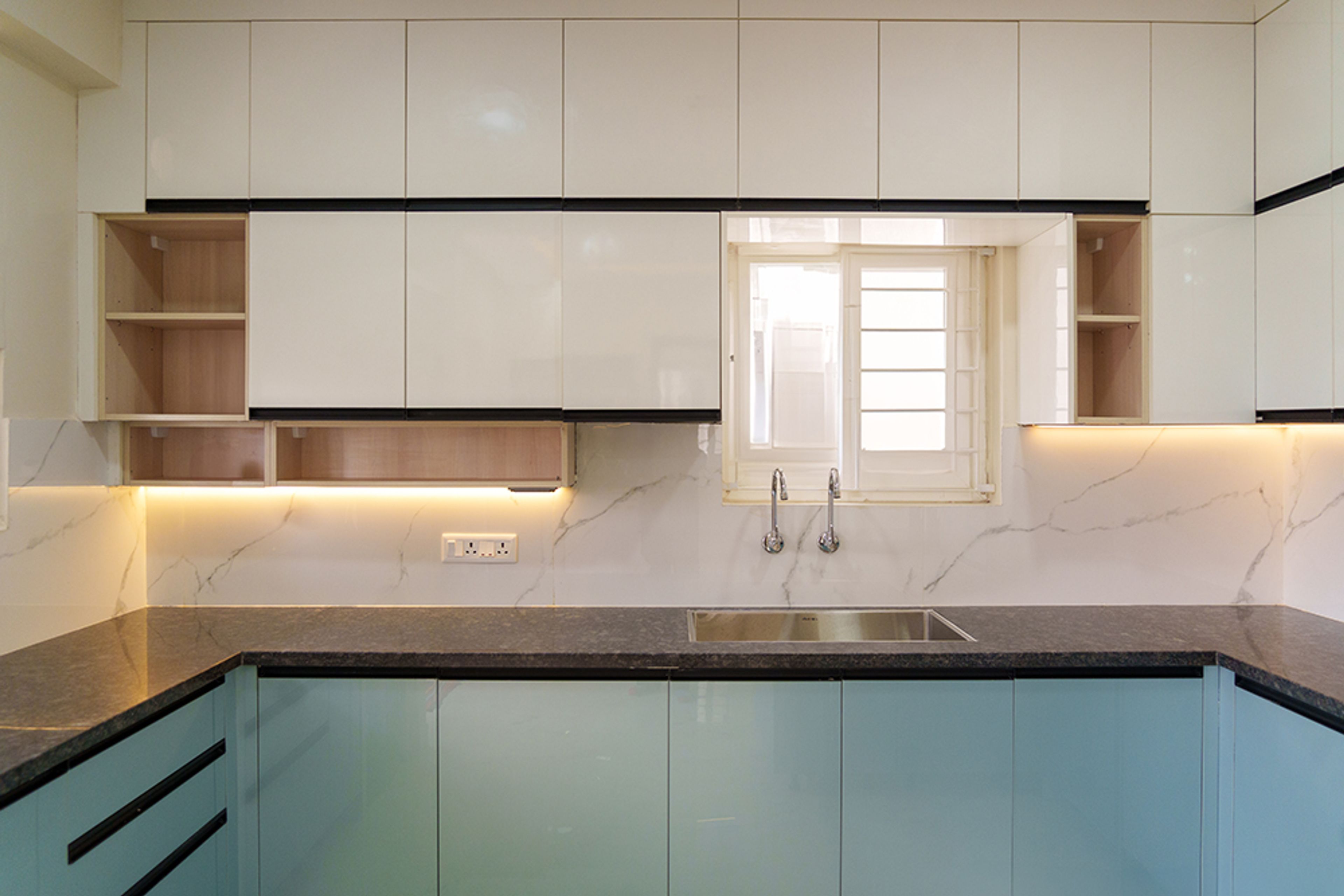 U-Shaped Kitchen Design with Aqua Blue Base Cabinets, White Overhead Cabinets, and Black Granite Countertop with Pendant Lights