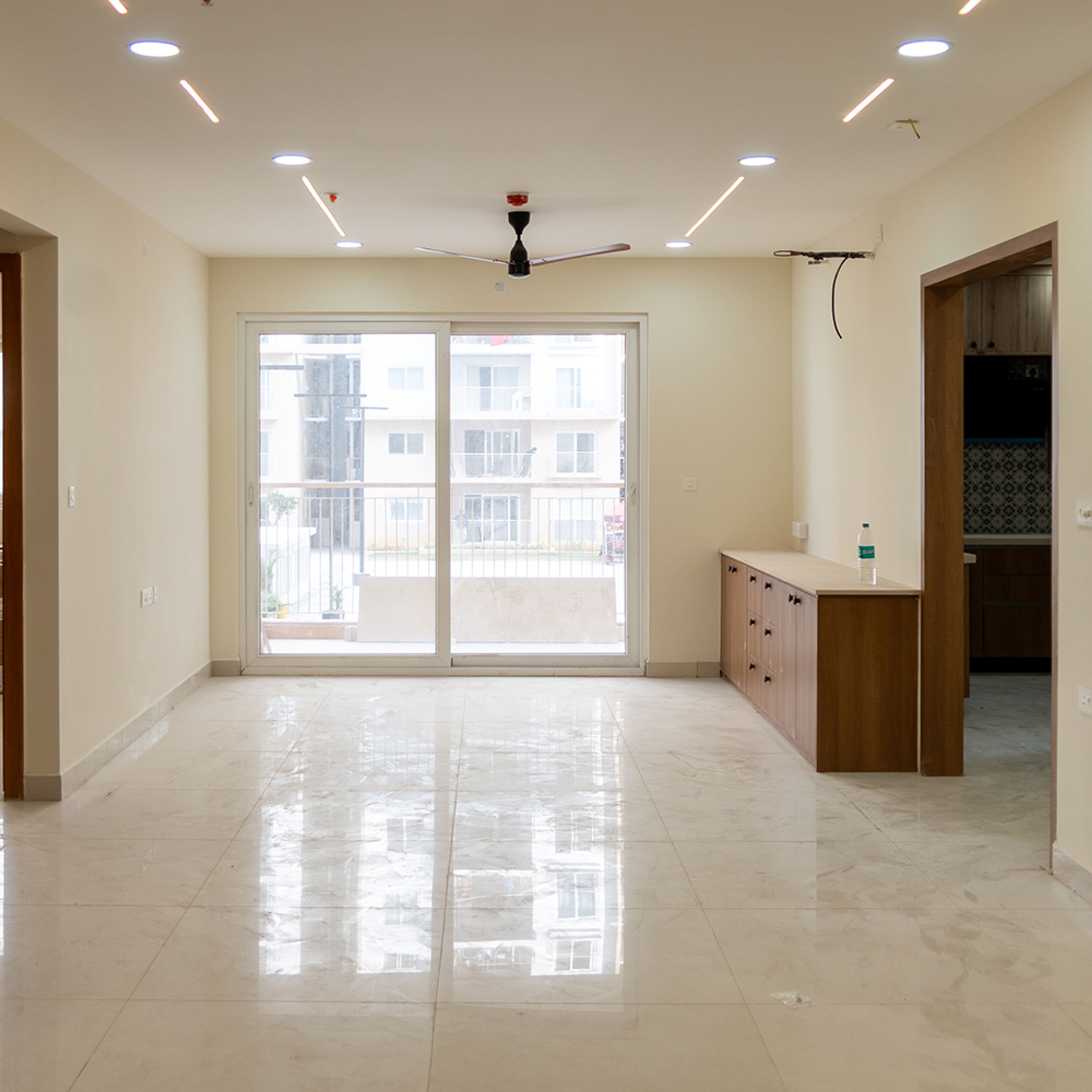 Living Room Design with Wooden TV Unit and Single Layer False Ceiling with Strip Lights
