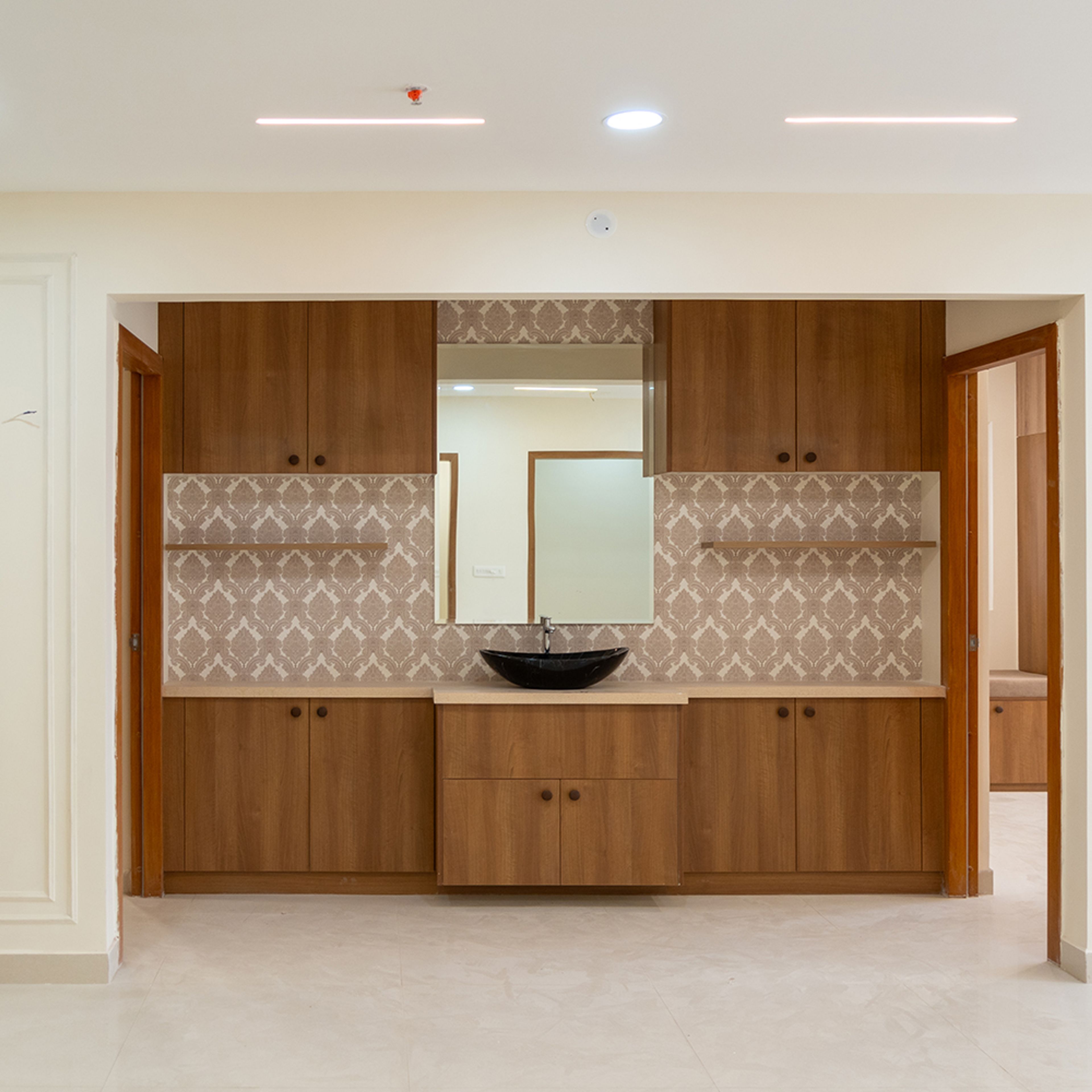 Crockery Unit Design with Wooden Cabinets, Ethnic Motif Backsplash and Mirror with Sink