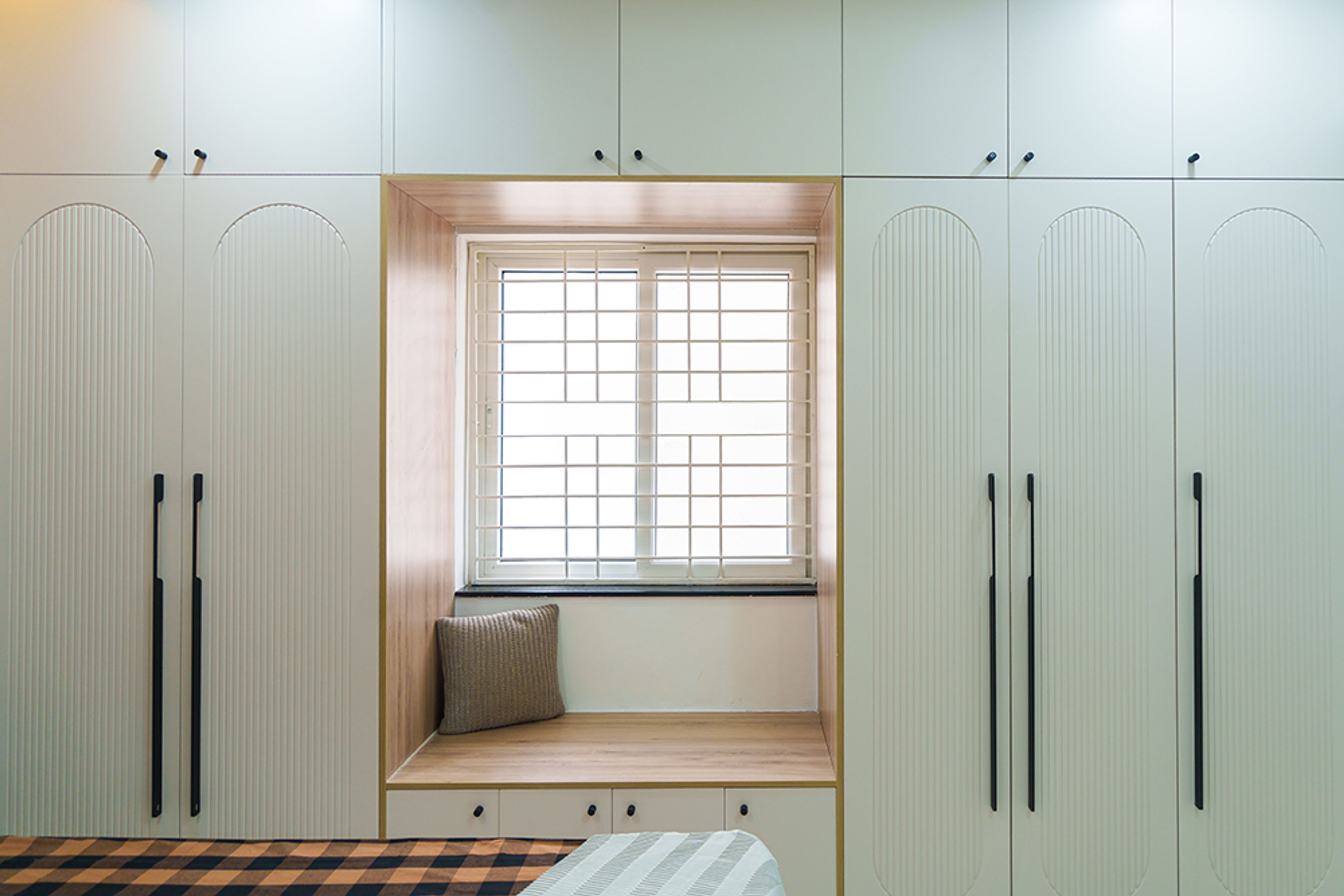 5-door cream swing wardrobe design with seating space in between