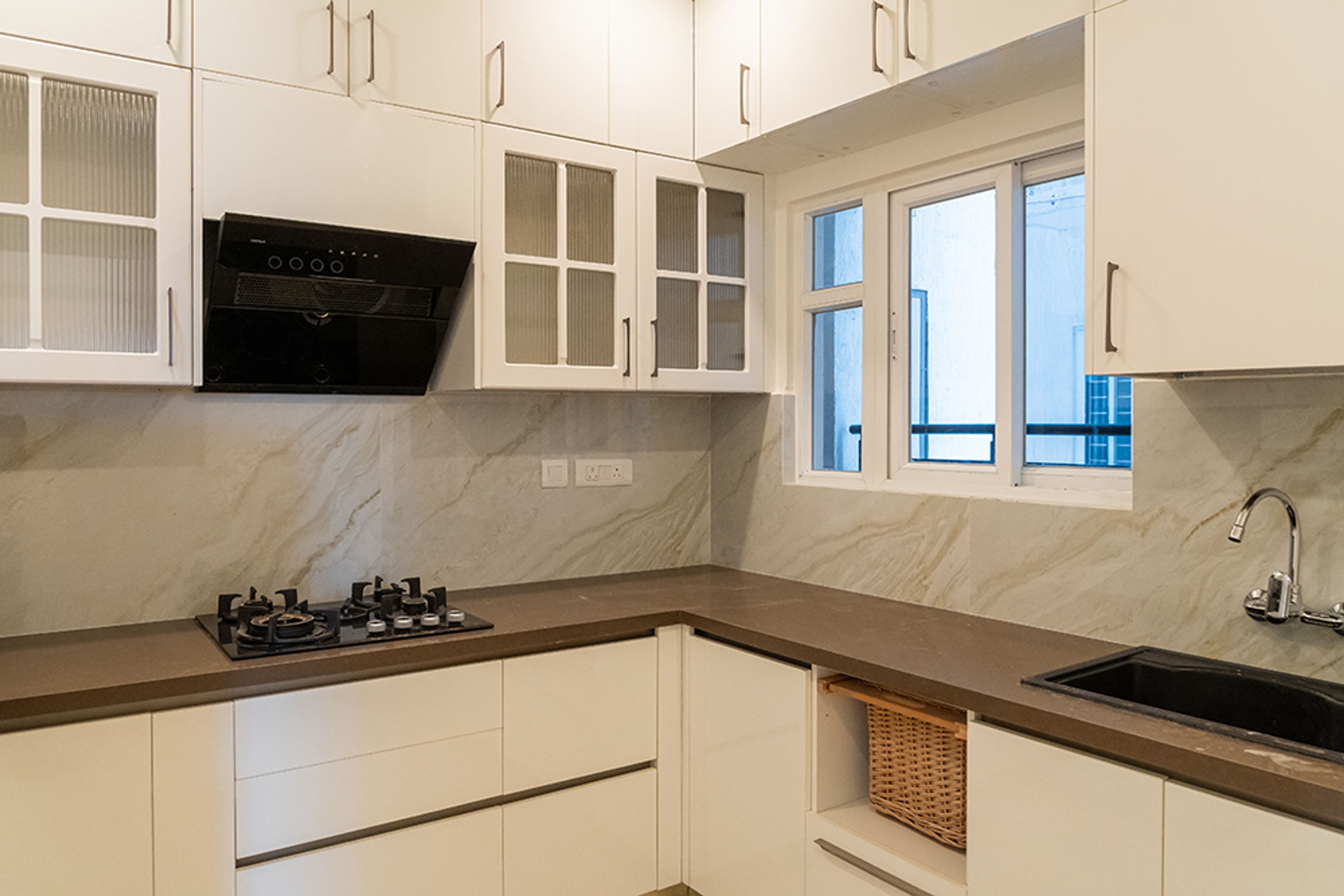 L-Shaped Kitchen Design with White Cabinets and Brown Granite Countertop