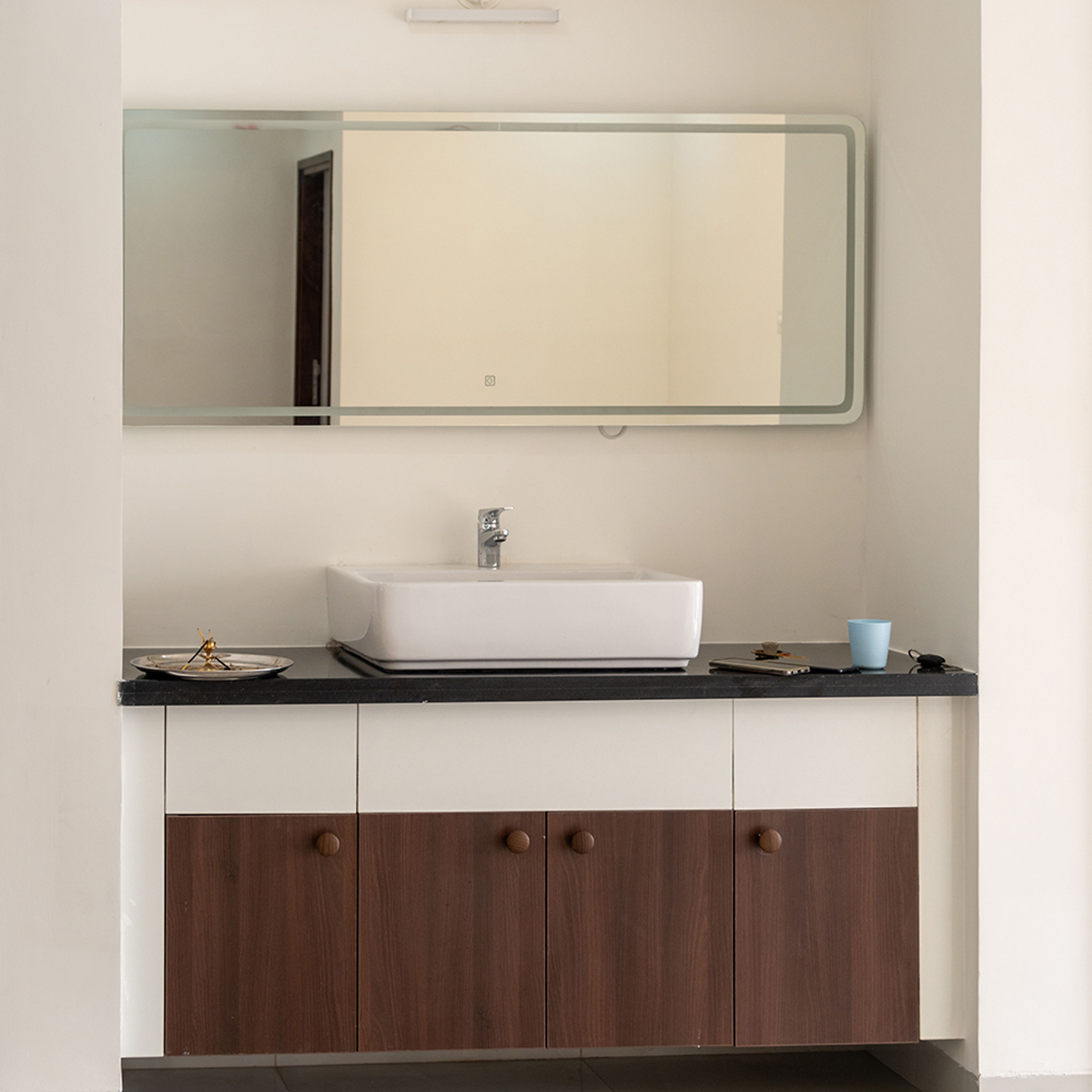 Vanity Area with White Sink and Wooden and White Cabinets