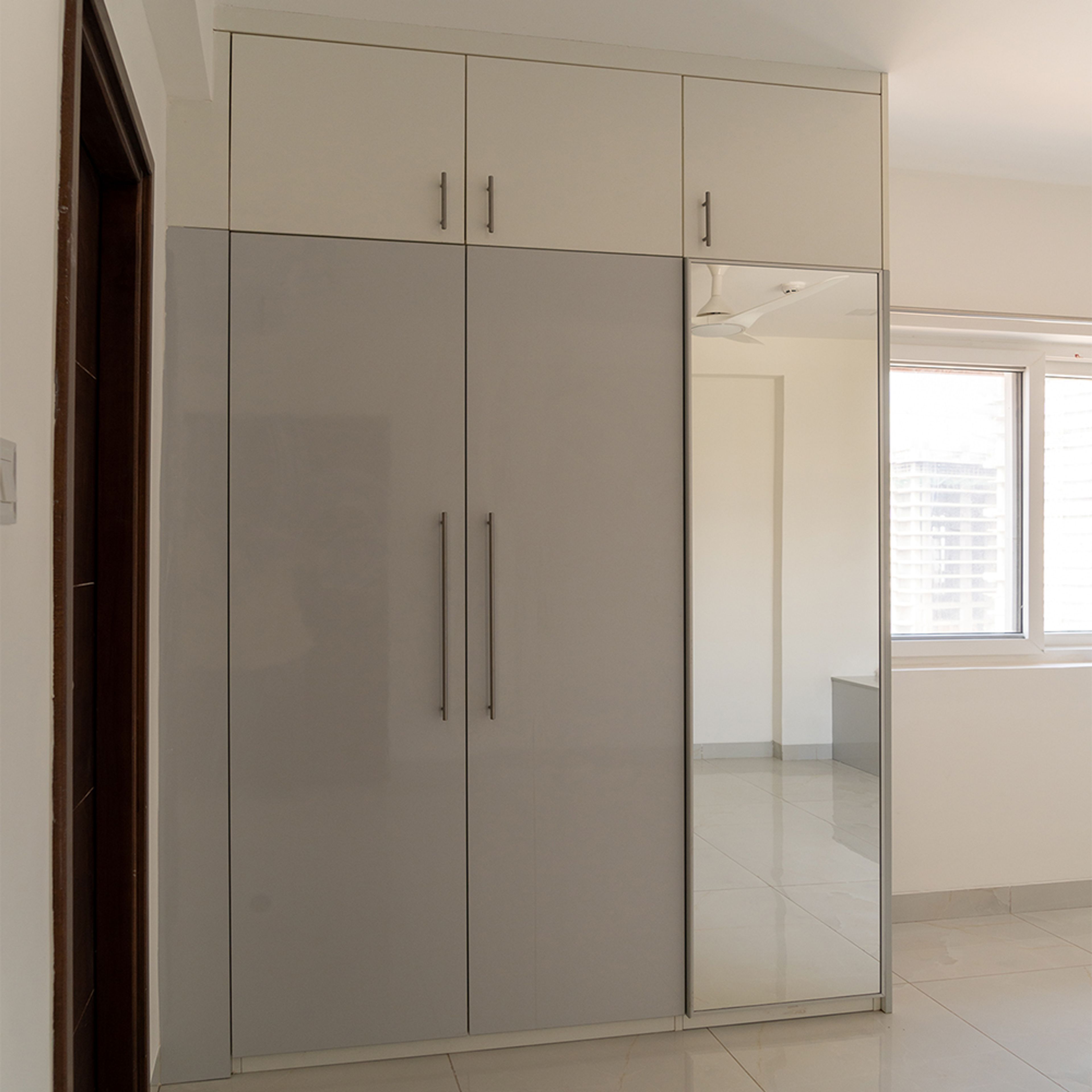 3-Door Grey Swing Wardrobe Design With Integrated Mirror and Loft Unit