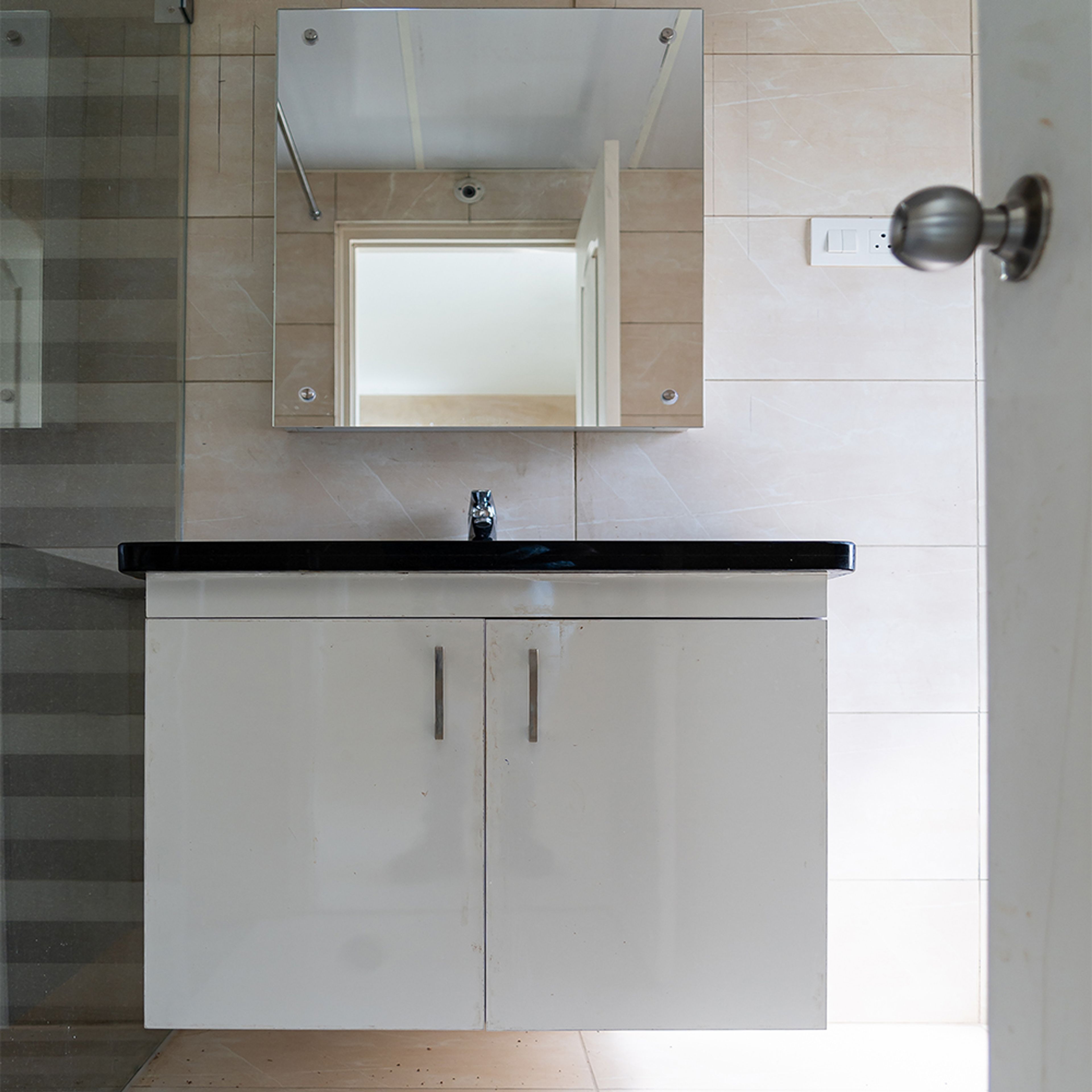 Bathroom design with white cabinets and square mirror