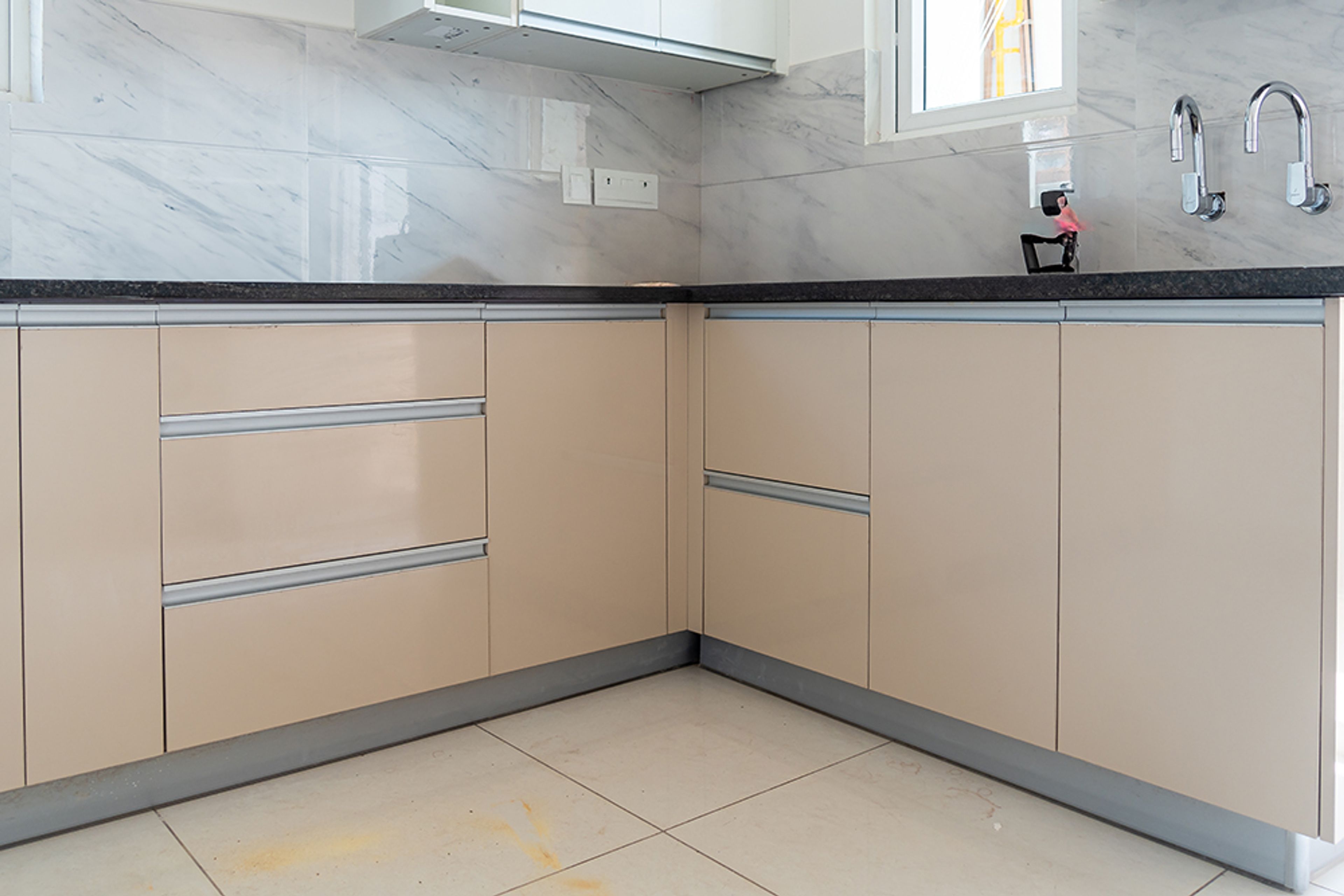 L-shaped kitchen design with peach base unit