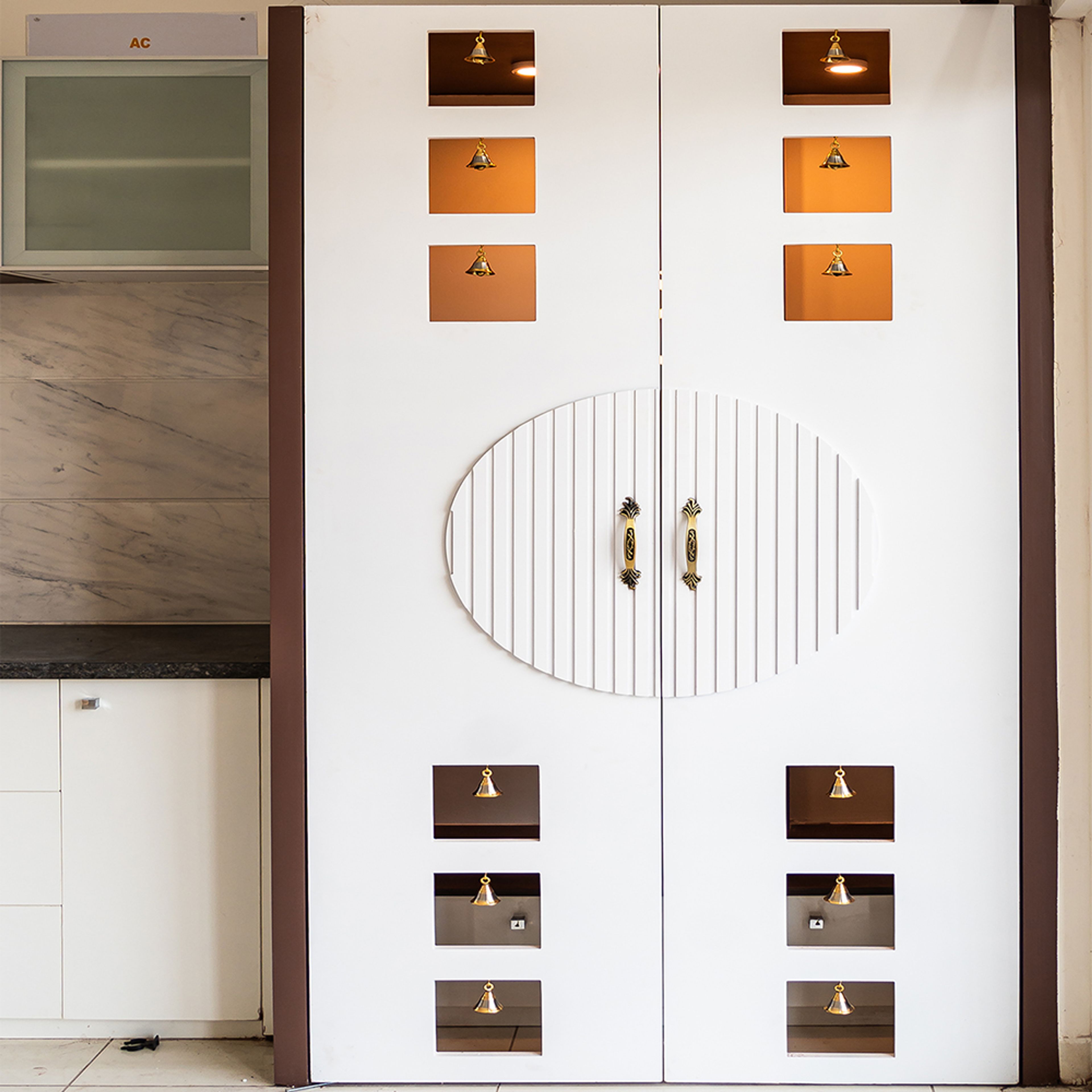 Pooja unit with white door with bells