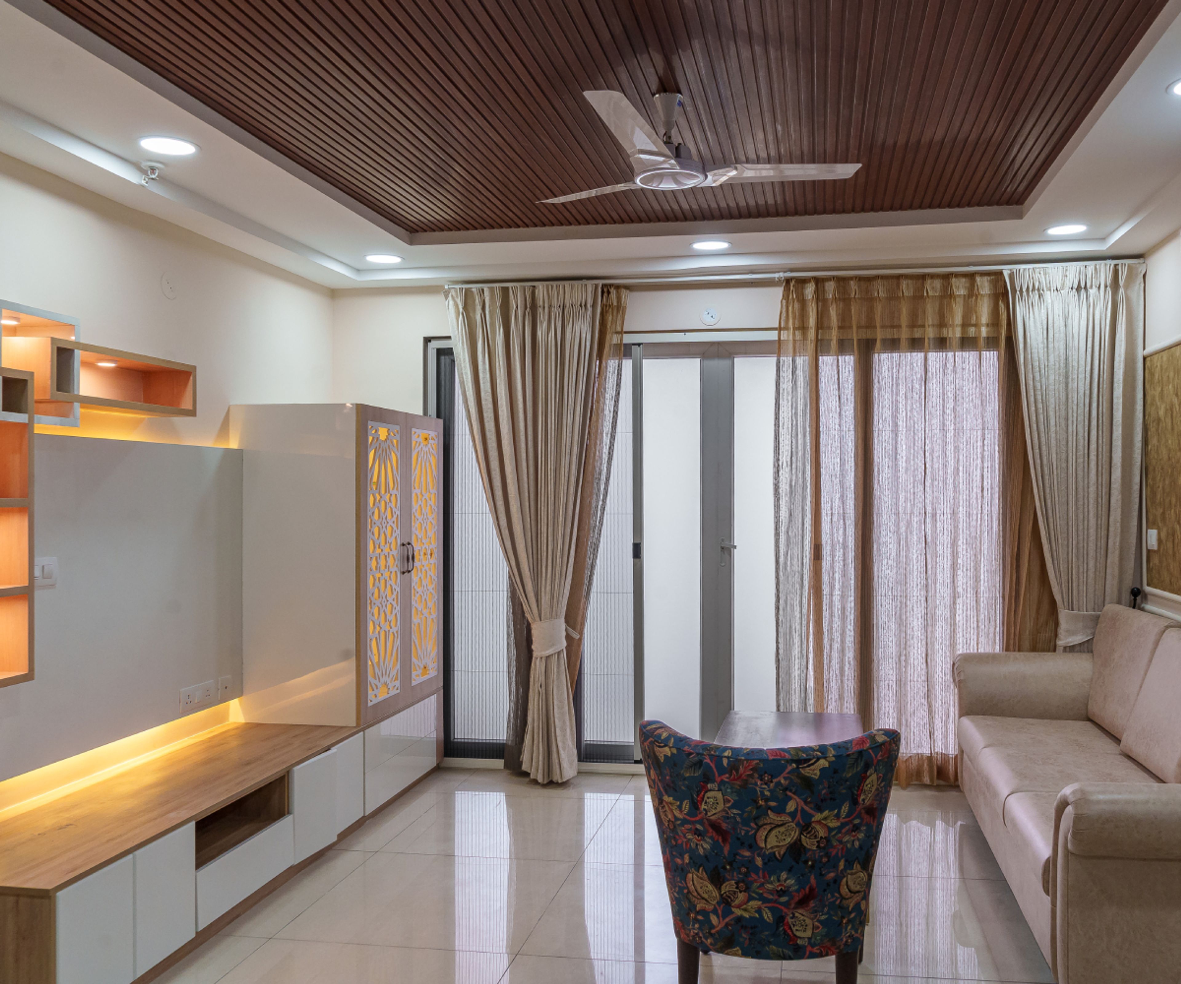 Living Room Design with Beige Sofa, TV Unit and Closed Pooja Unit