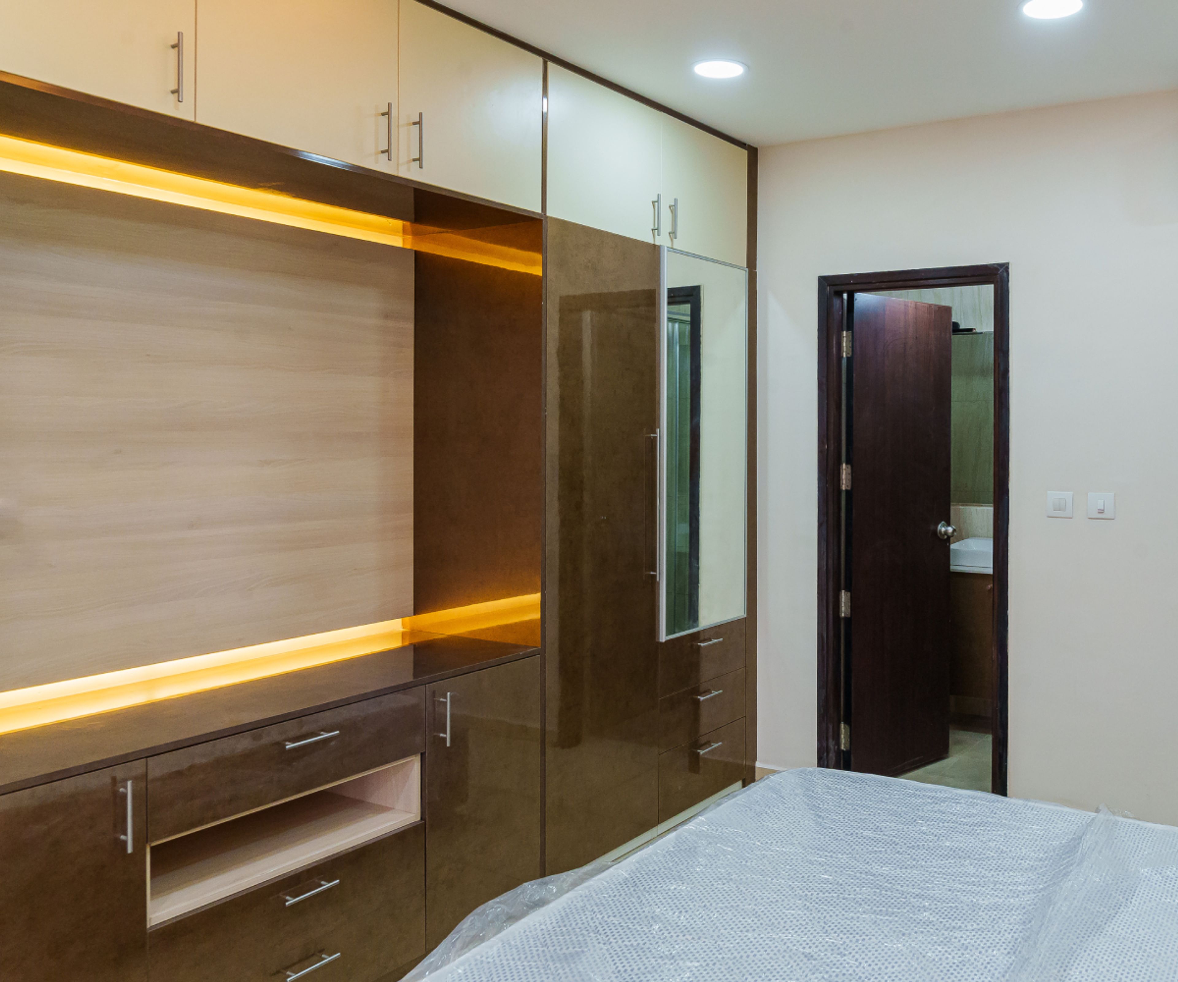 Guest Bedroom Design with 4-Door Swing Wardrobe with Integrated Mirror and TV Unit
