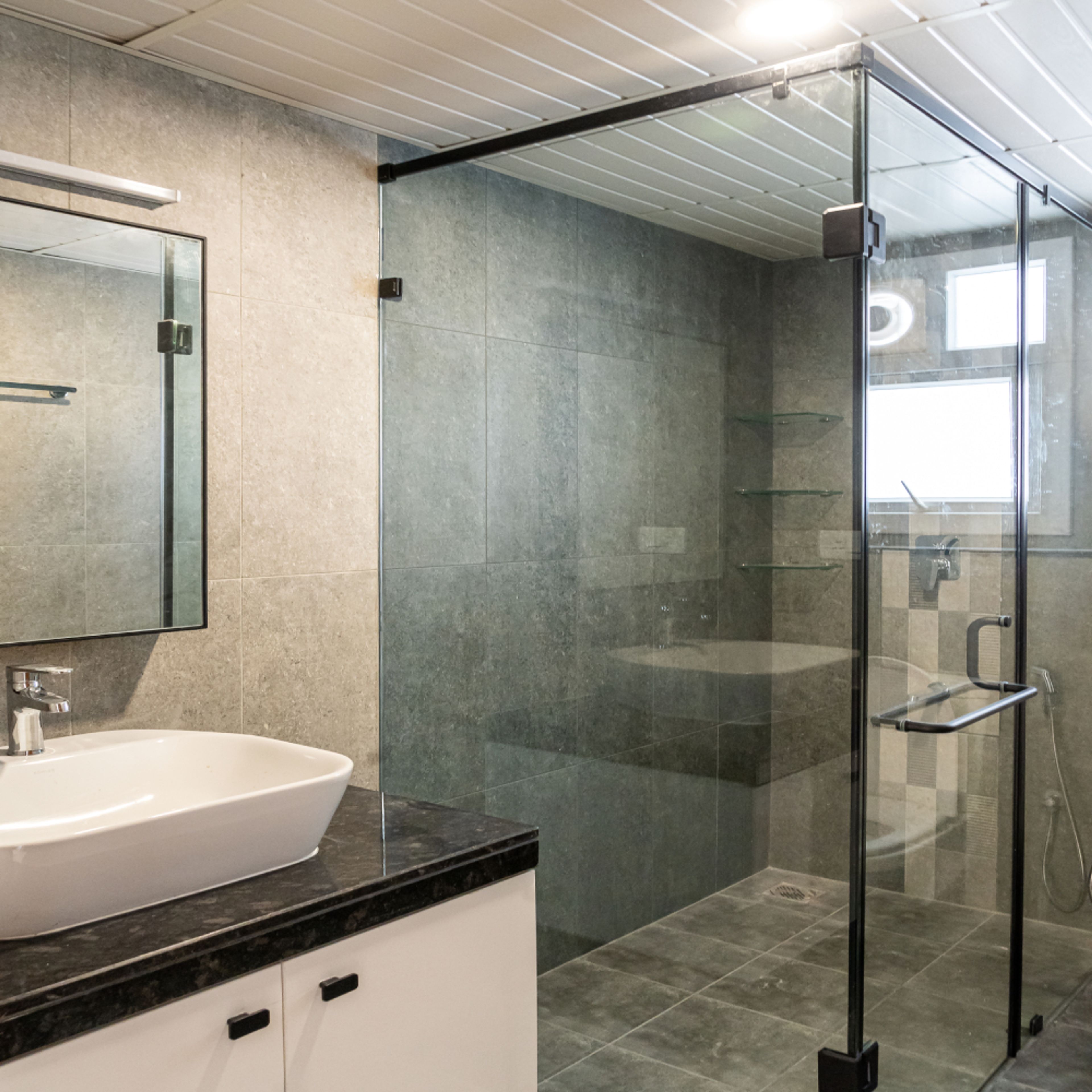 Bathroom Design with White Under Cabinet and Glass Partition Shower Area