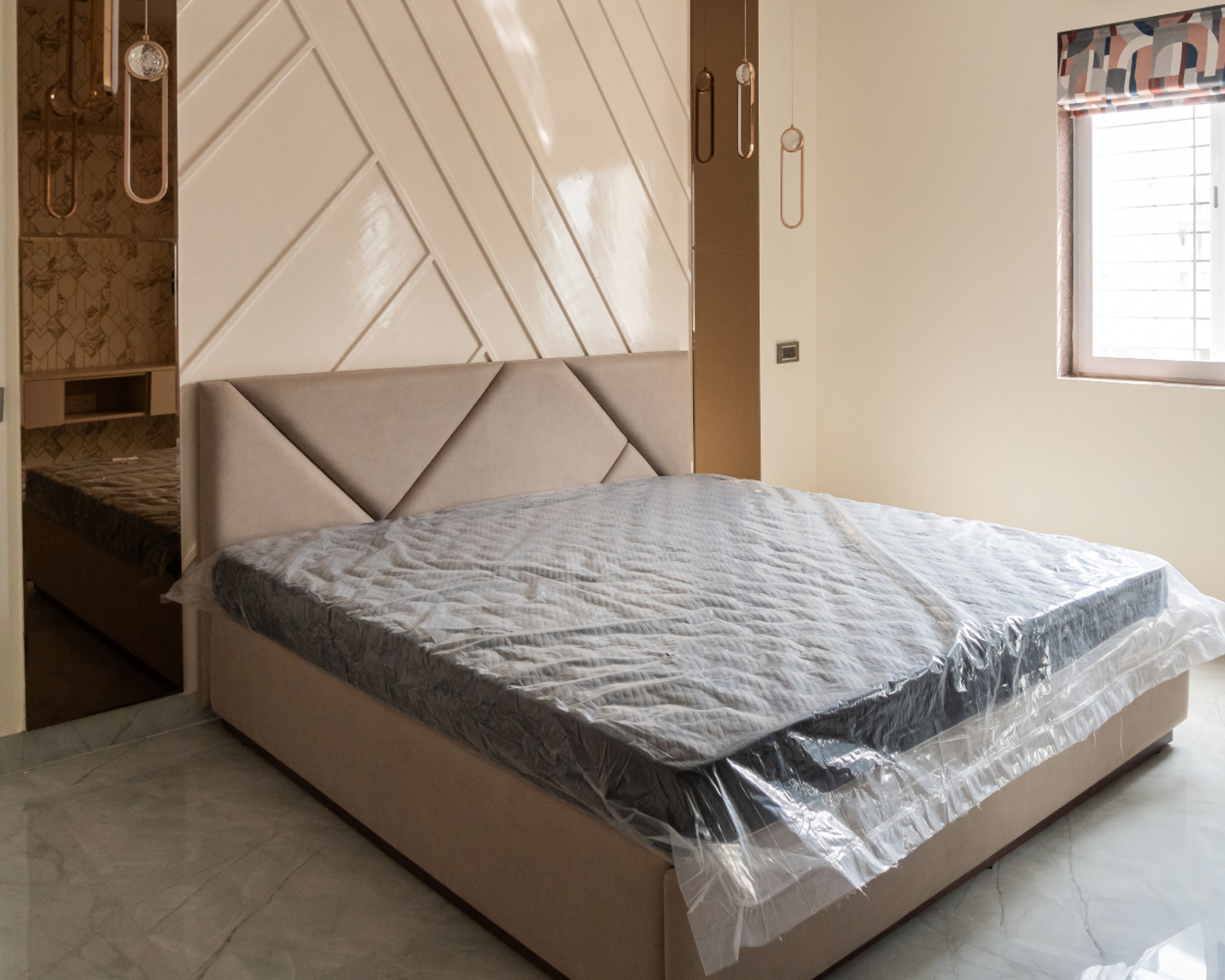Master Bedroom Design with Glossy Diagonal Panel Wall, Upholstered Geometric Headboard, Pendant Lighting, and Marble Flooring